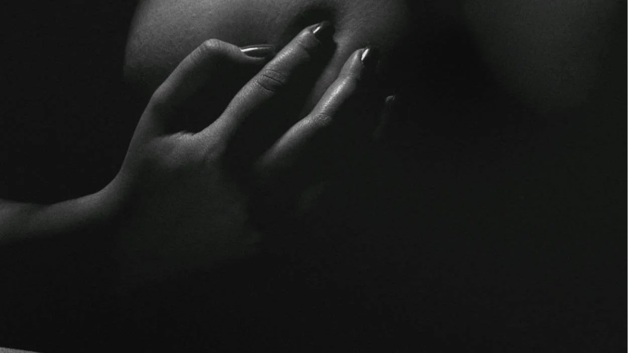 Dark and luxurious boudoir photography example for the Kindred Spirit Squarespace portfolio template, showing a close detail of a hand on the body to convey emotion and texture.