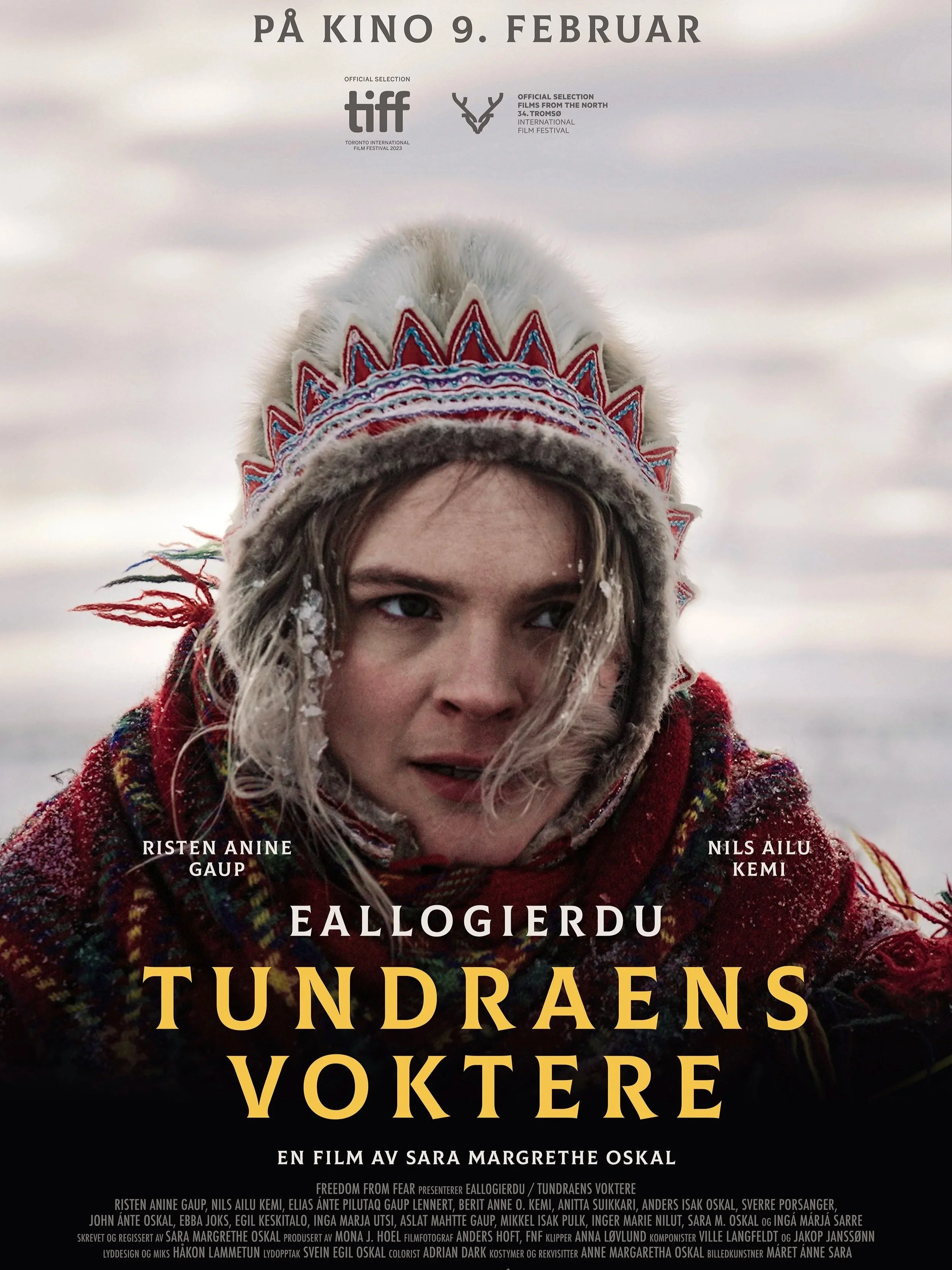 En filmplakat for filmen "tundraens voktere". På plakaten ser man et nærbilde av en samisk dame i vinterklær. Hun er ute og det er kaldt rundt hun. Tittelen er tydelig i gul skrift på nedre halvdel av plakaten