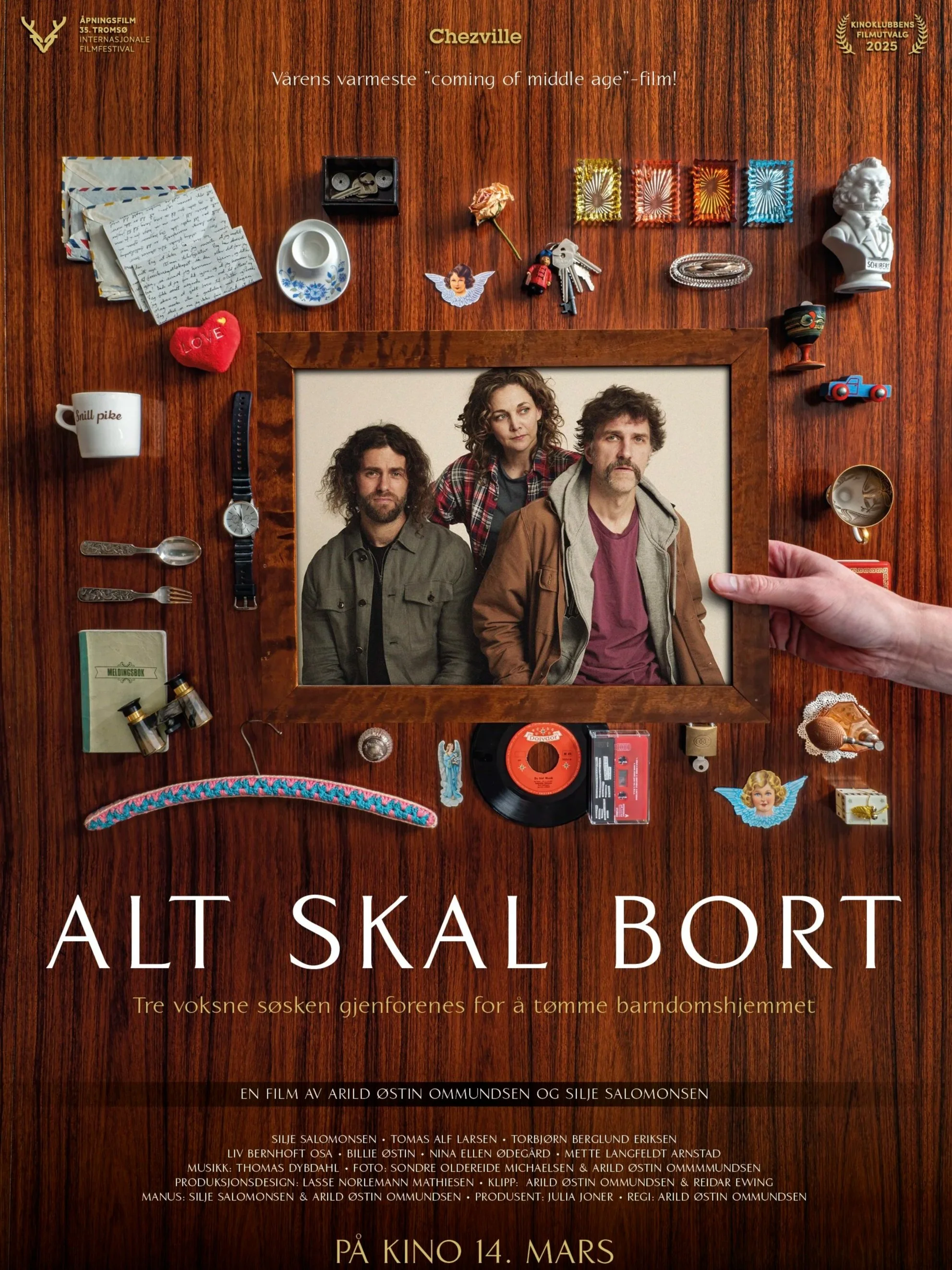 Postermal for filmen 'Alt skal bort', En hånd holder et bilde av tre voksne søsken, omgitt av små gjenstander og leker, teksten er hvit og på norsk. 