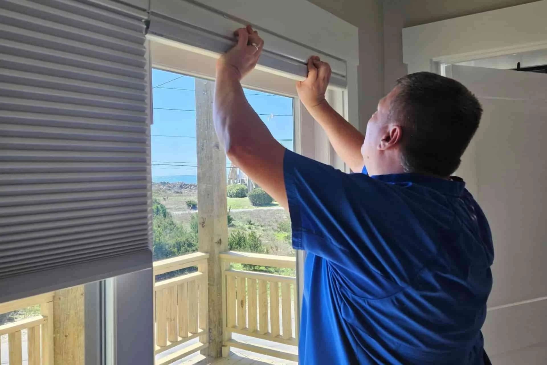 a man professionally installing window treatments