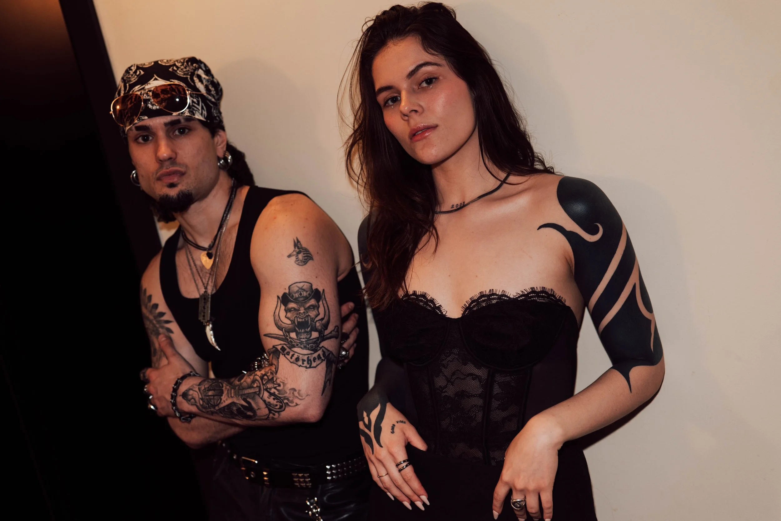 Hombre con tatuajes y accesorios oscuros y mujer con tatuajes y vestido de encaje negro