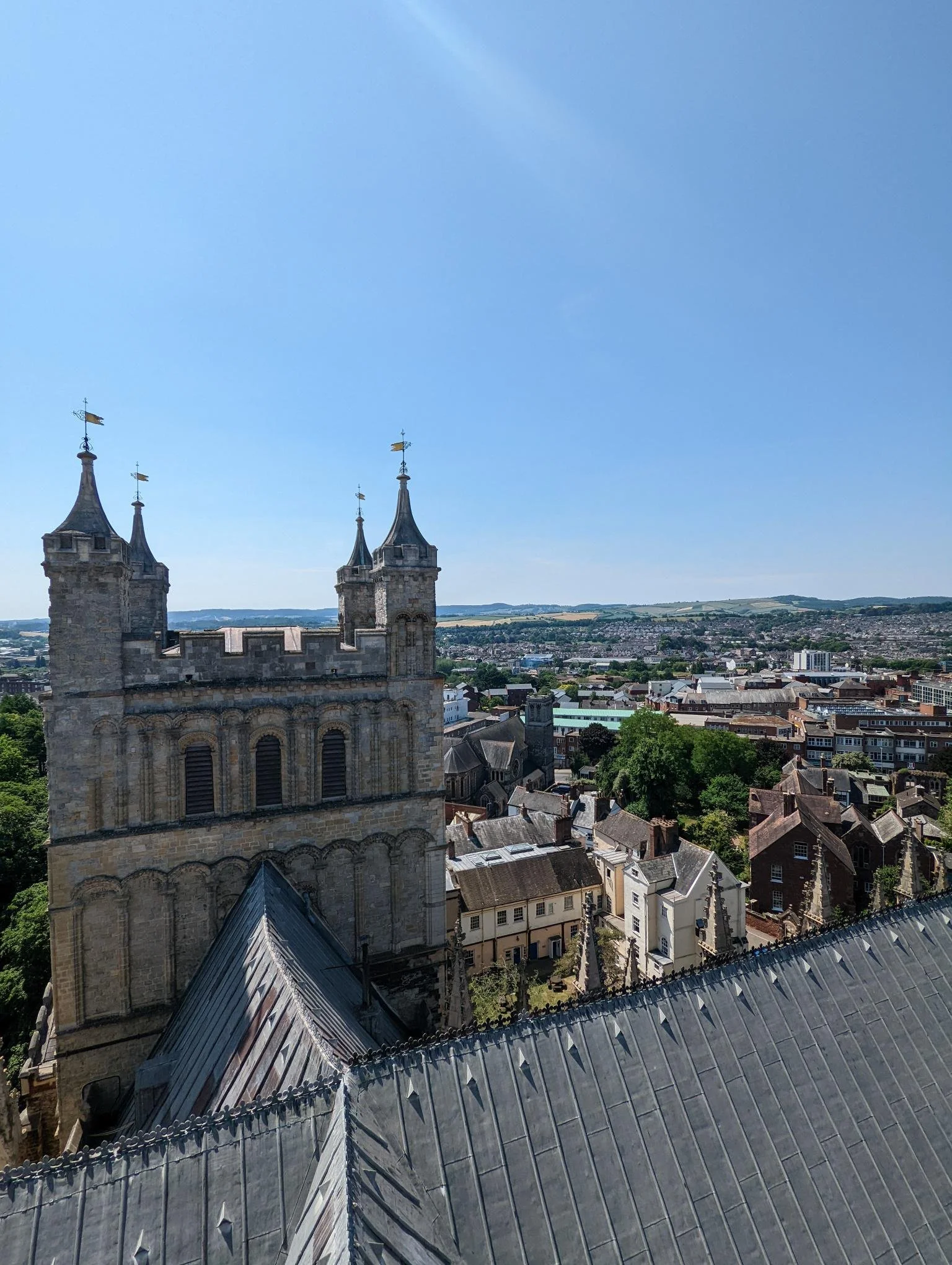 A cathedral tower in the foreground and city buildings below.
