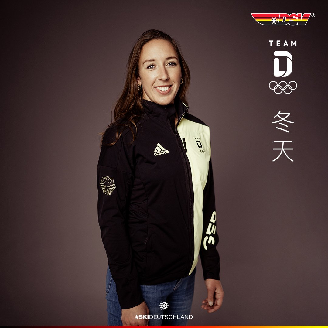 Woman wearing German ski team jacket with Olympic logo and #SKIDEUTSCHLAND, posing in front of DSV branding.