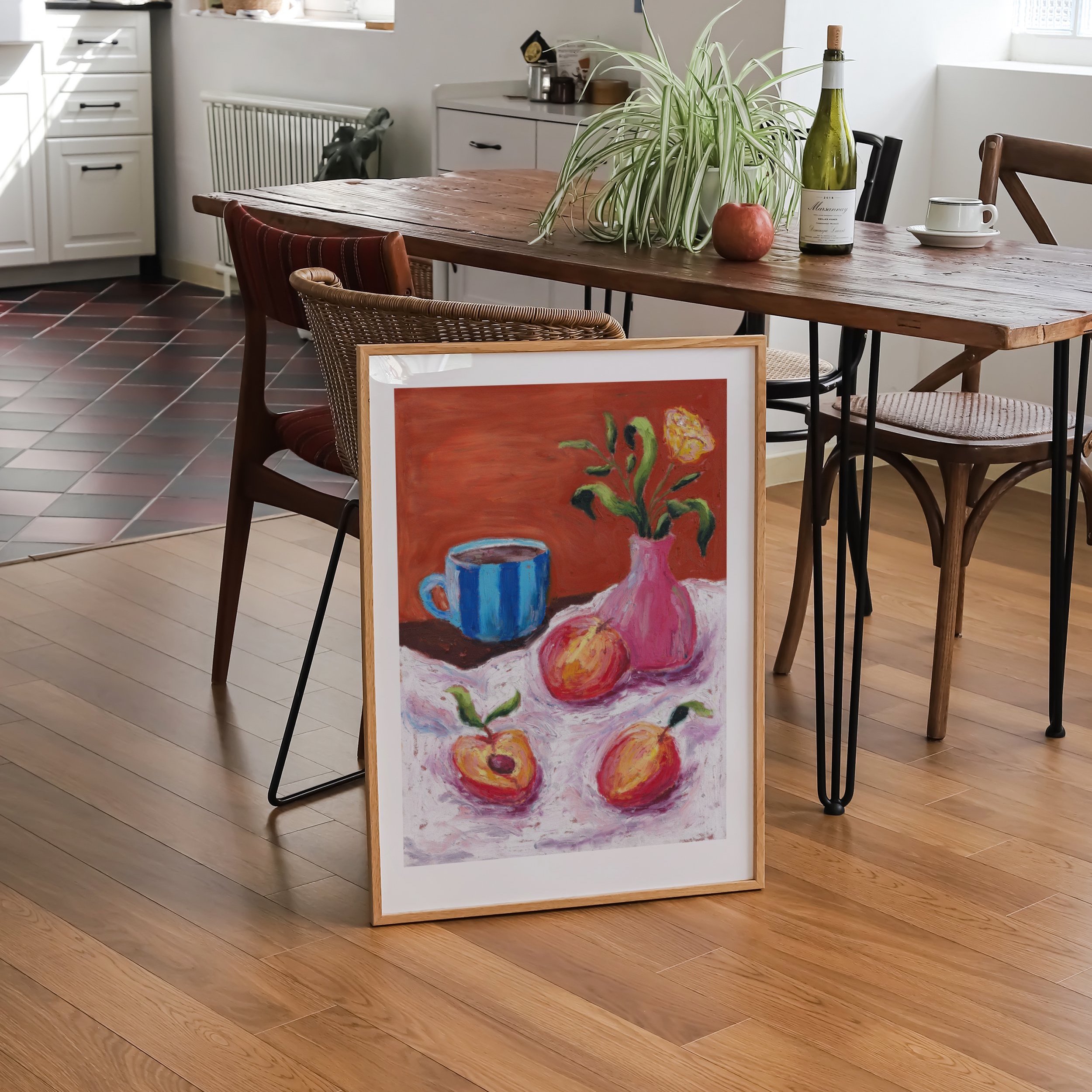 A wooden framed print of an oil pastel painting of peaches, coffee and flowers in a dining room
