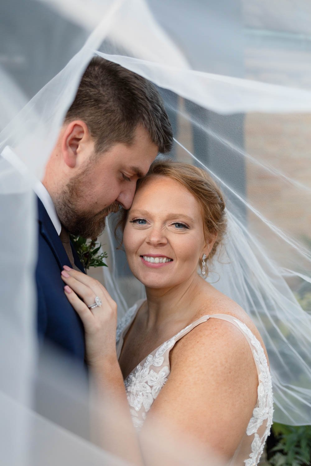 Bride looking at camera and smiling under veil