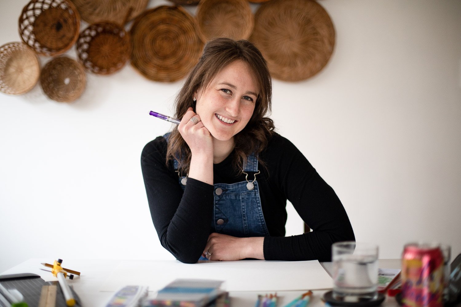 Alison Kroening smiling and holding a paintbrush