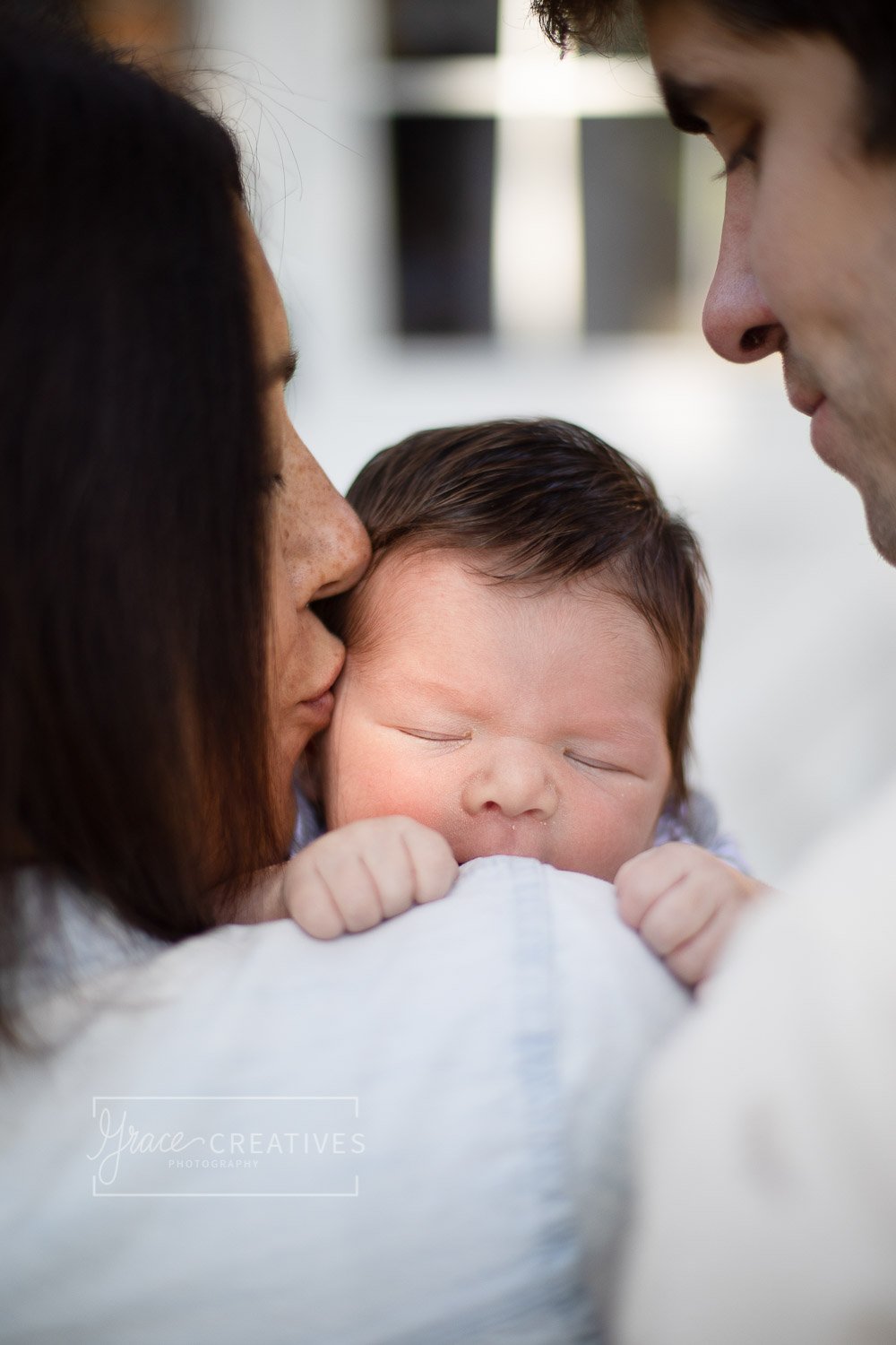 Mother kissing newborn's temple