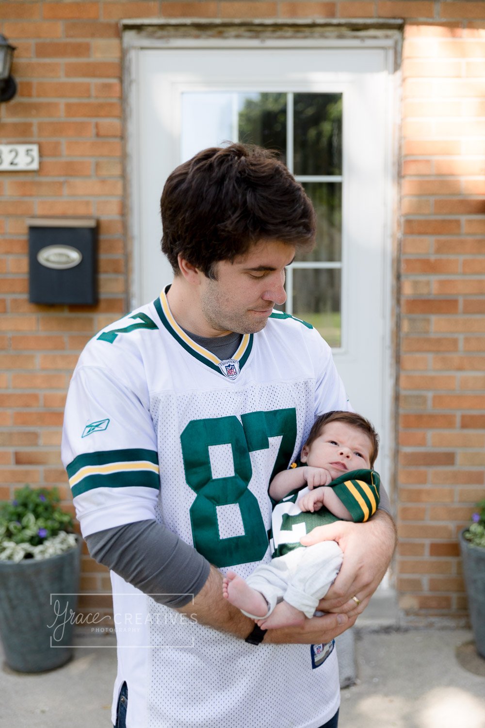 Father and newborn son wearing Packers jerseys