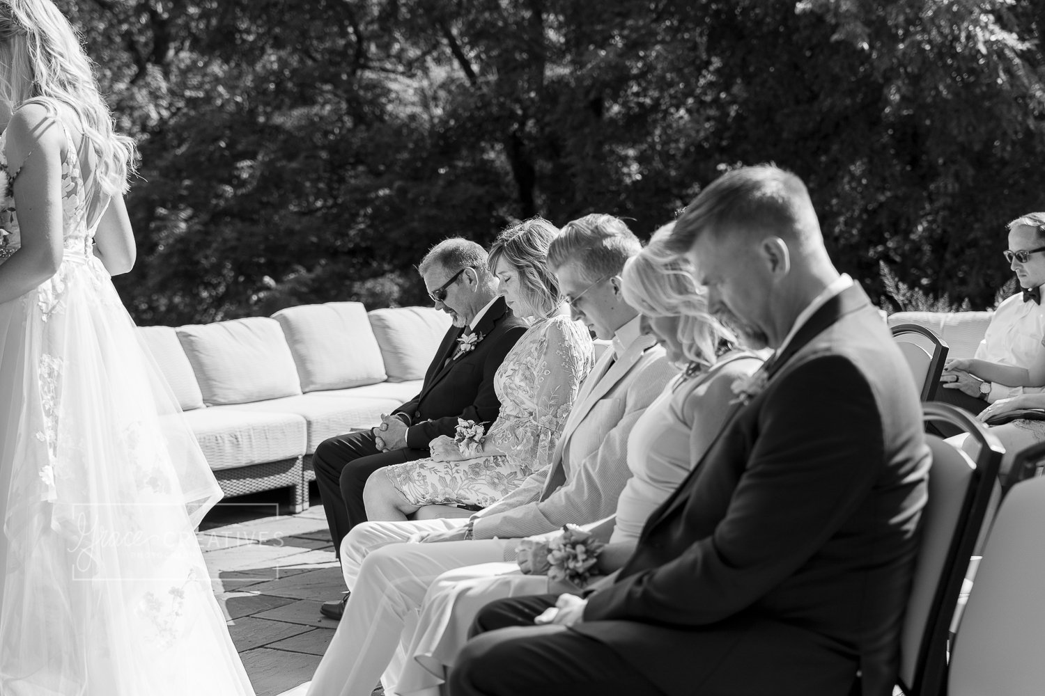 Front row of guests praying during wedding ceremony