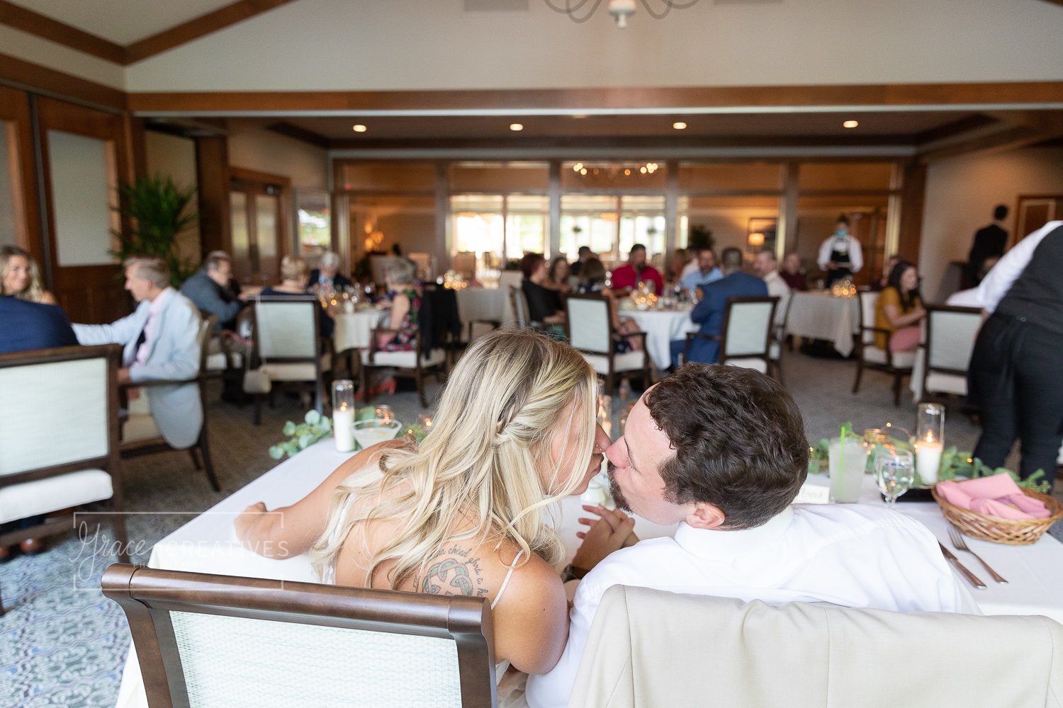 Bride and Groom kissing during Reception Dinner at chenequa country club