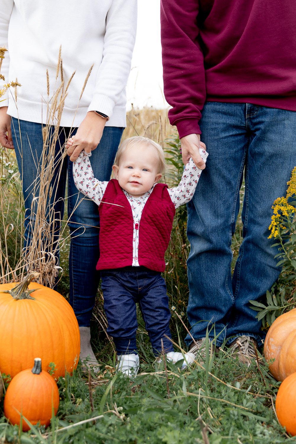 One year old photos during family of three standing in a field during fall 2020 mini sessions