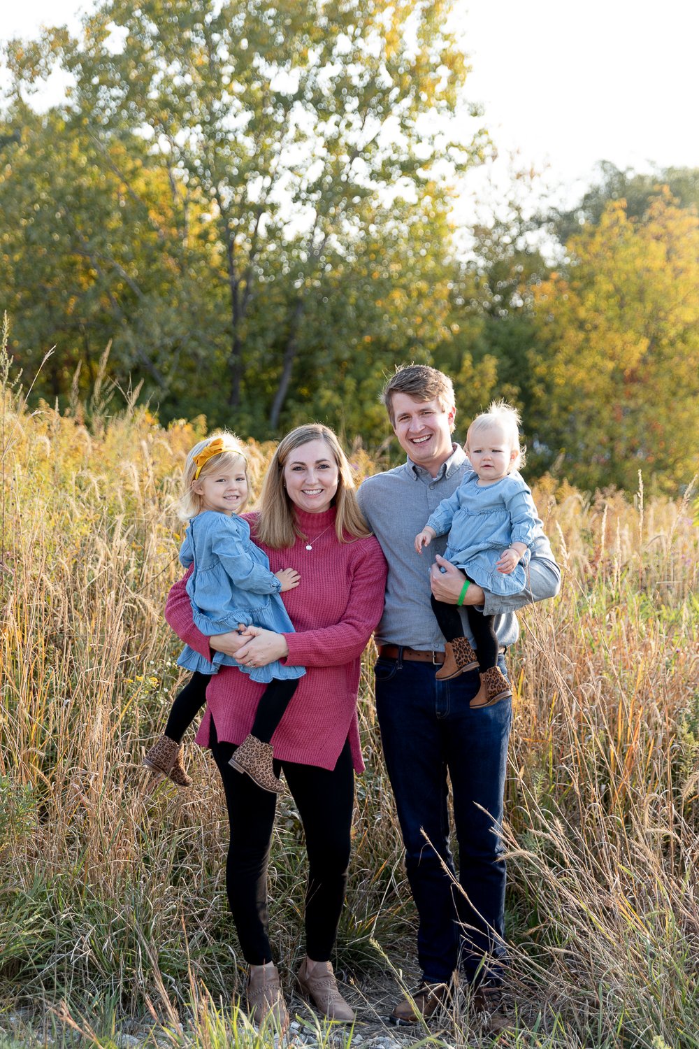family of four standing in long grass in hartung park in tosa during fall mini session with grace creatives photography