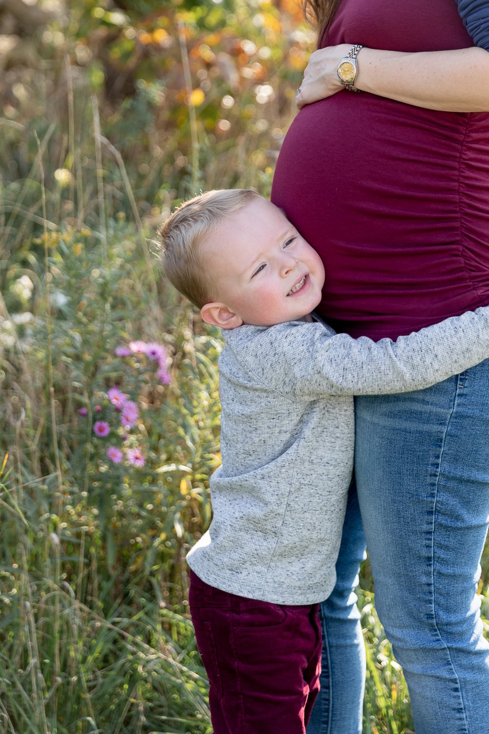 son hugging his pregnant mother's belly during family photos at fall 2020 mini sessions with grace creatives