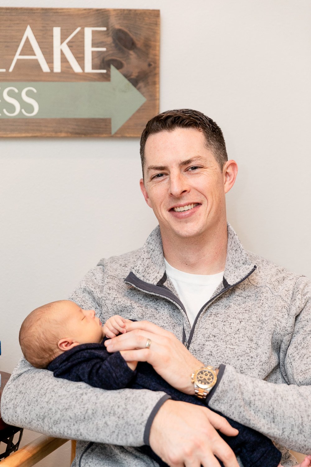 Father holding newborn during Pewaukee in-home newborn session with grace creatives