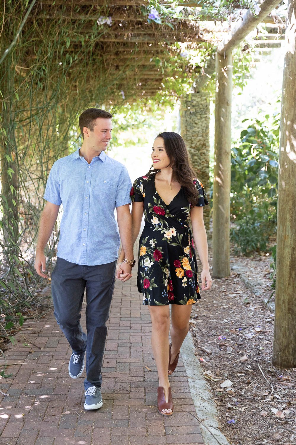 Couple walking hand in hand during Fairchild engagement session in Miami
