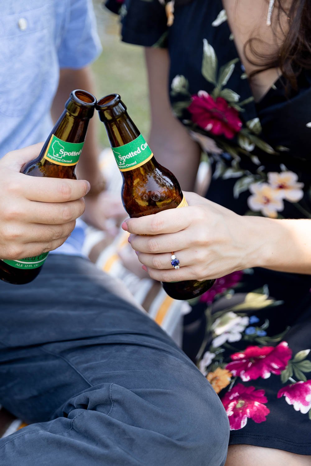 couple clinking their New Glarus Spotted Cow beers during engagement session at Fairchild Botanical Gardens