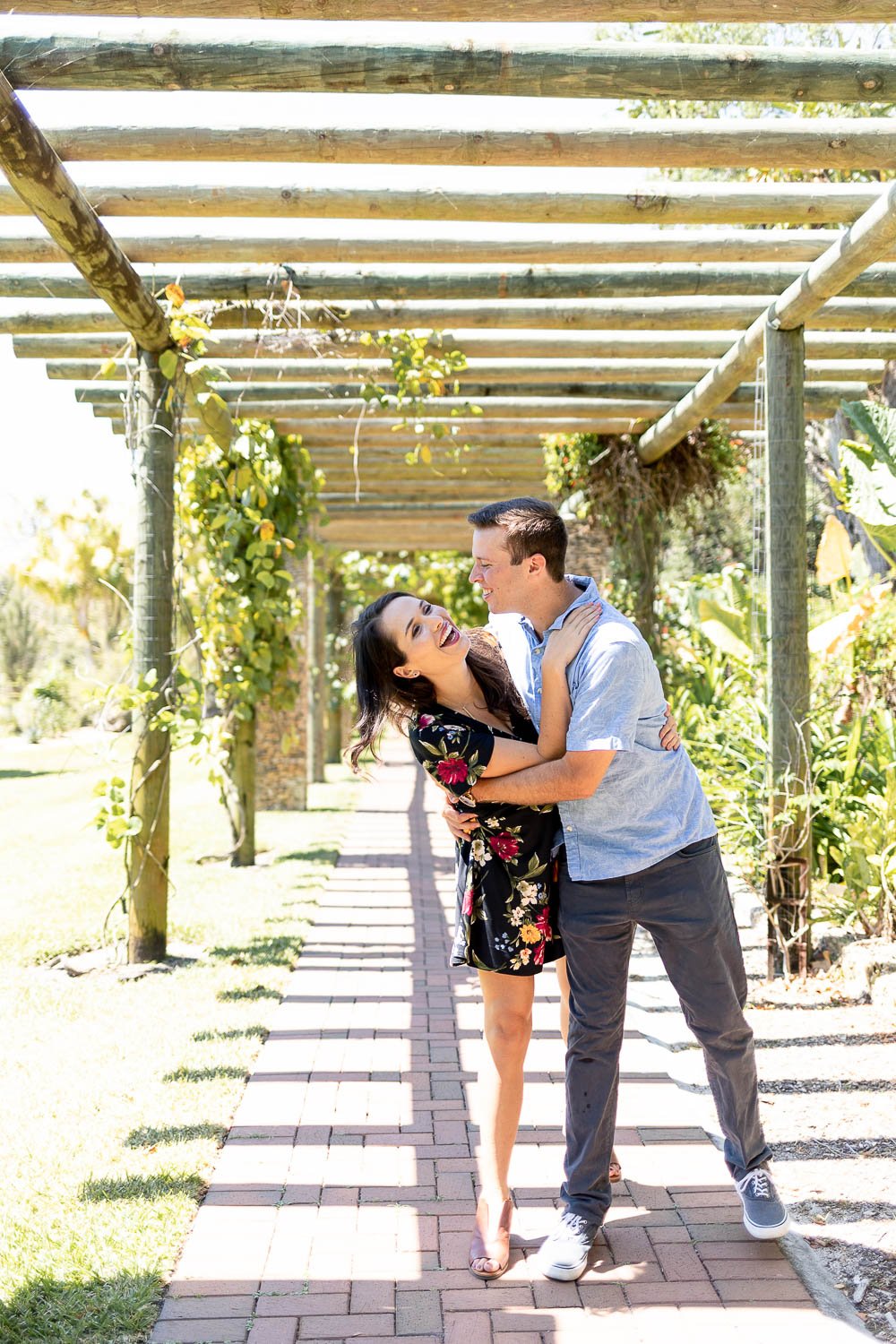 couple walking under canopy during engagement session at Fairchild botanical Gardens