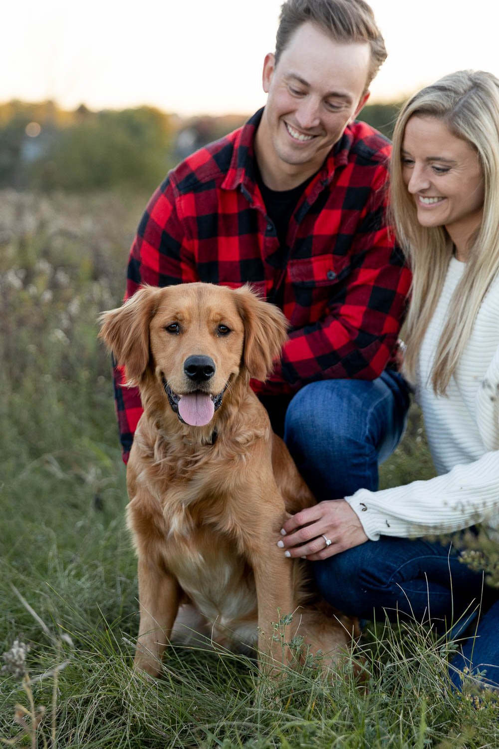 engaged couple sitting with their dog