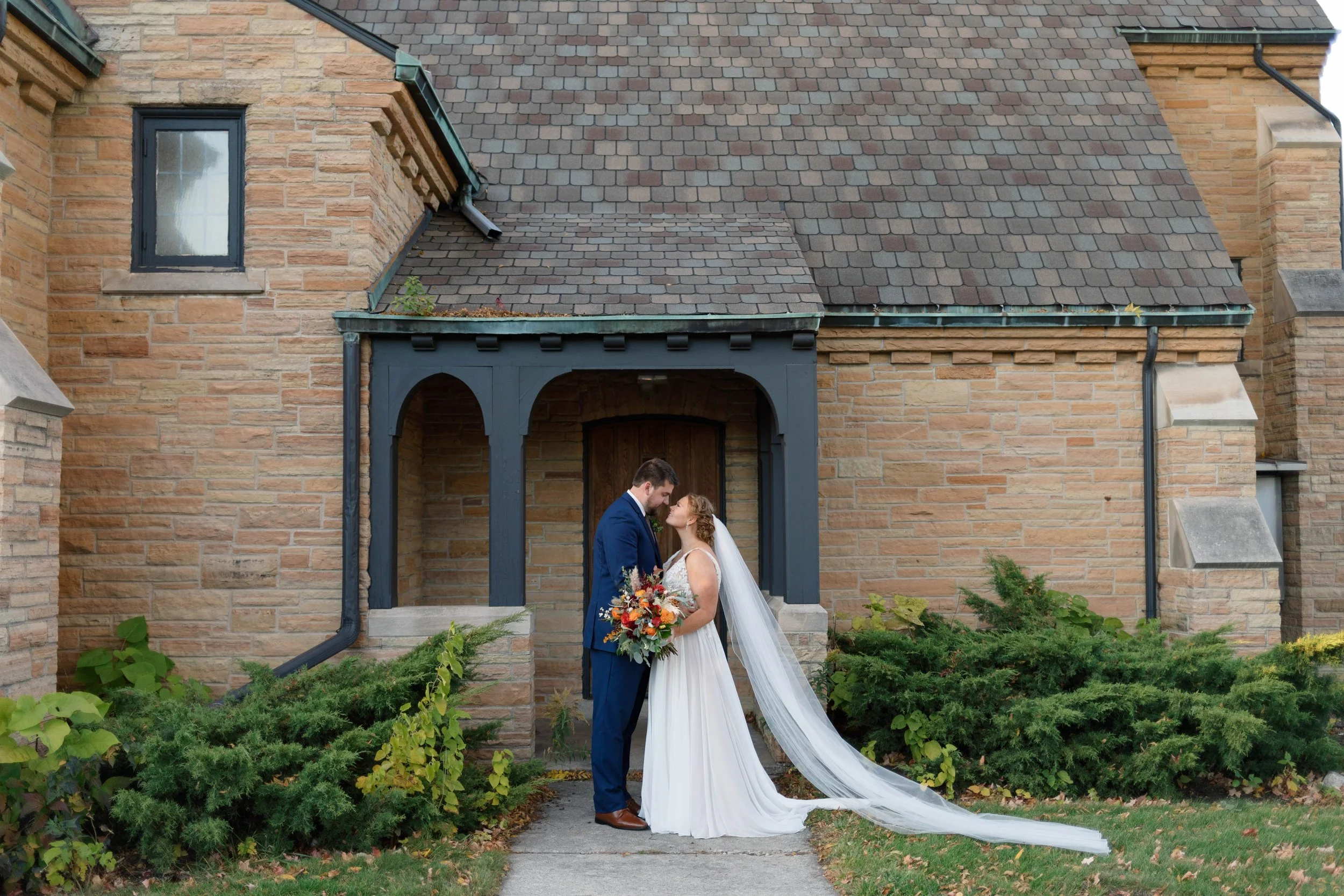 bride and groom standing with their noses touching