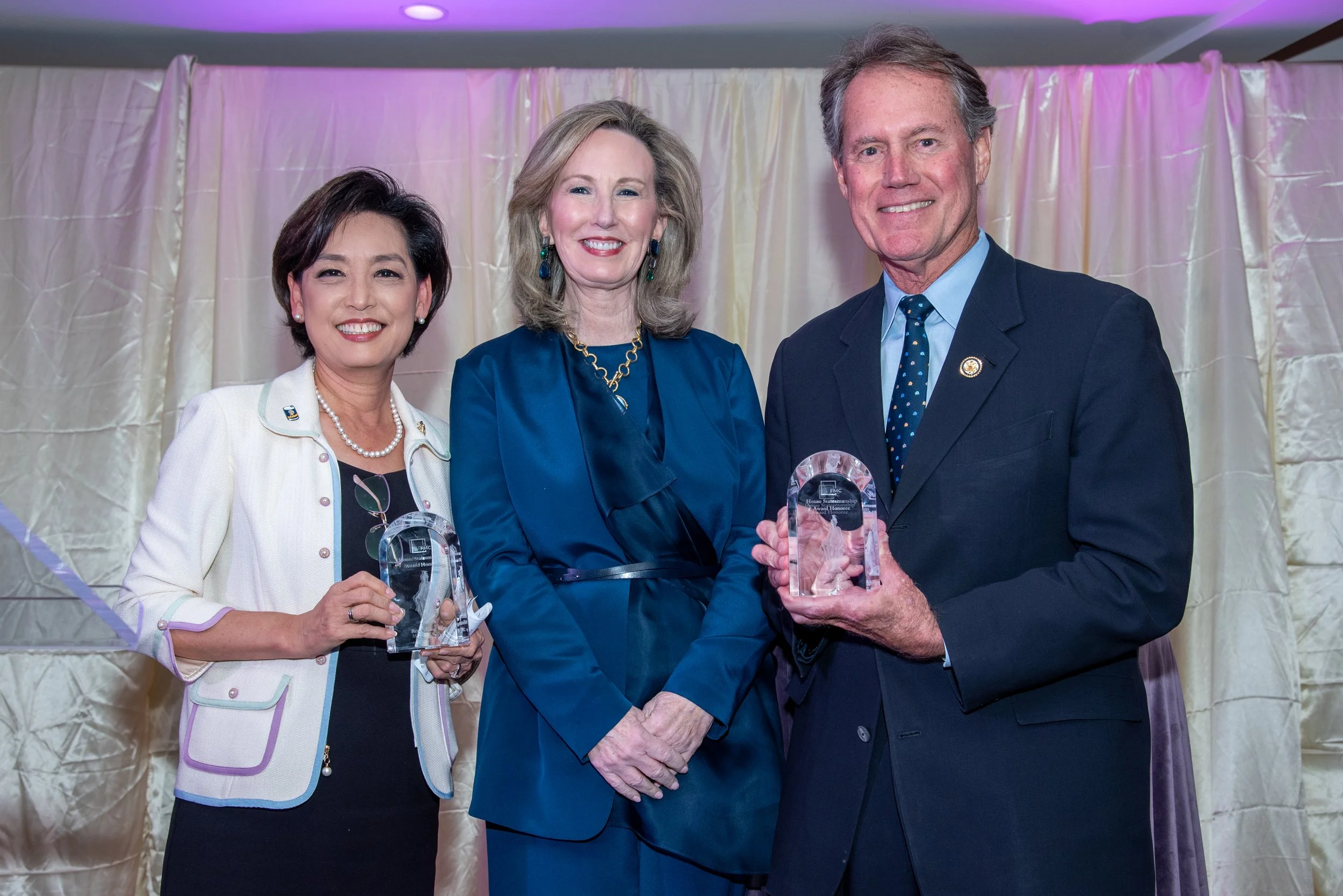 2025 Statesmanship Honorees Rep. Ed Case (D-HI, right) and Rep. Young Kim  (R-CA, left) pose with FMC President Barbara Comstock (R-VA, 2015-2019, center) after receiving their awards.