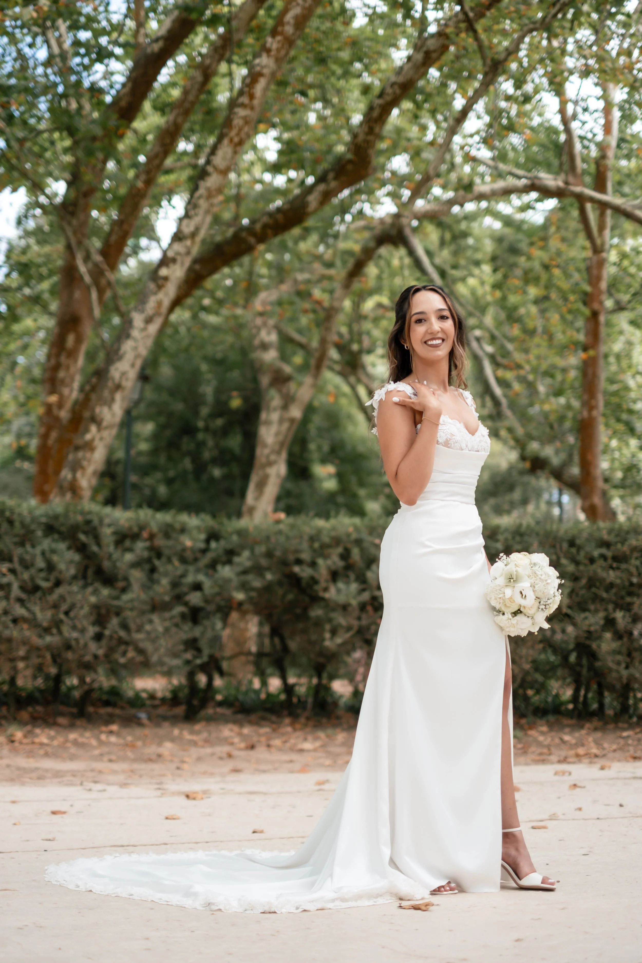 Noiva em retrato de corpo inteiro com vestido branco e bouquet