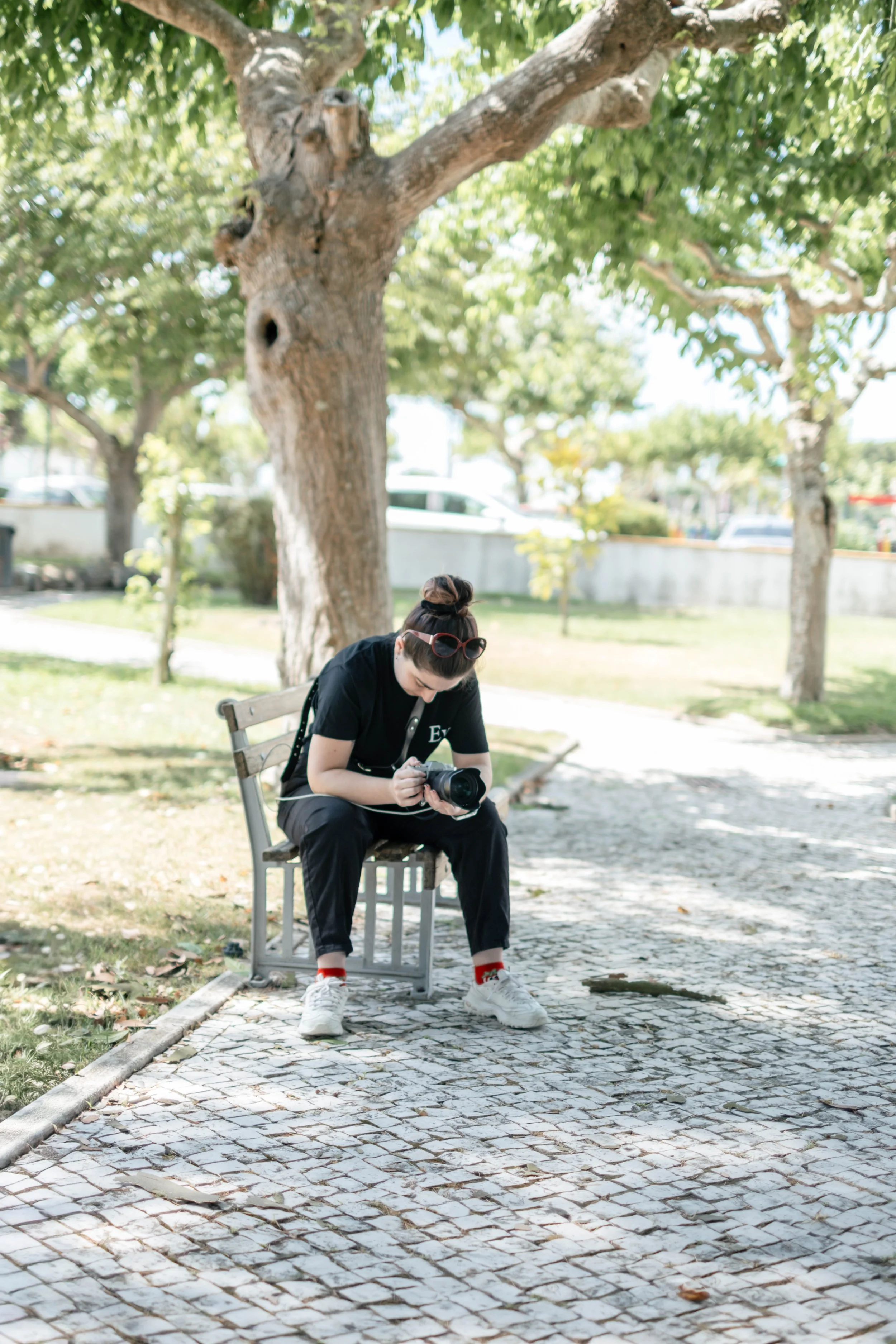 Eva, fotógrafa da Frutografia, sentada num banco a rever fotografias na câmara