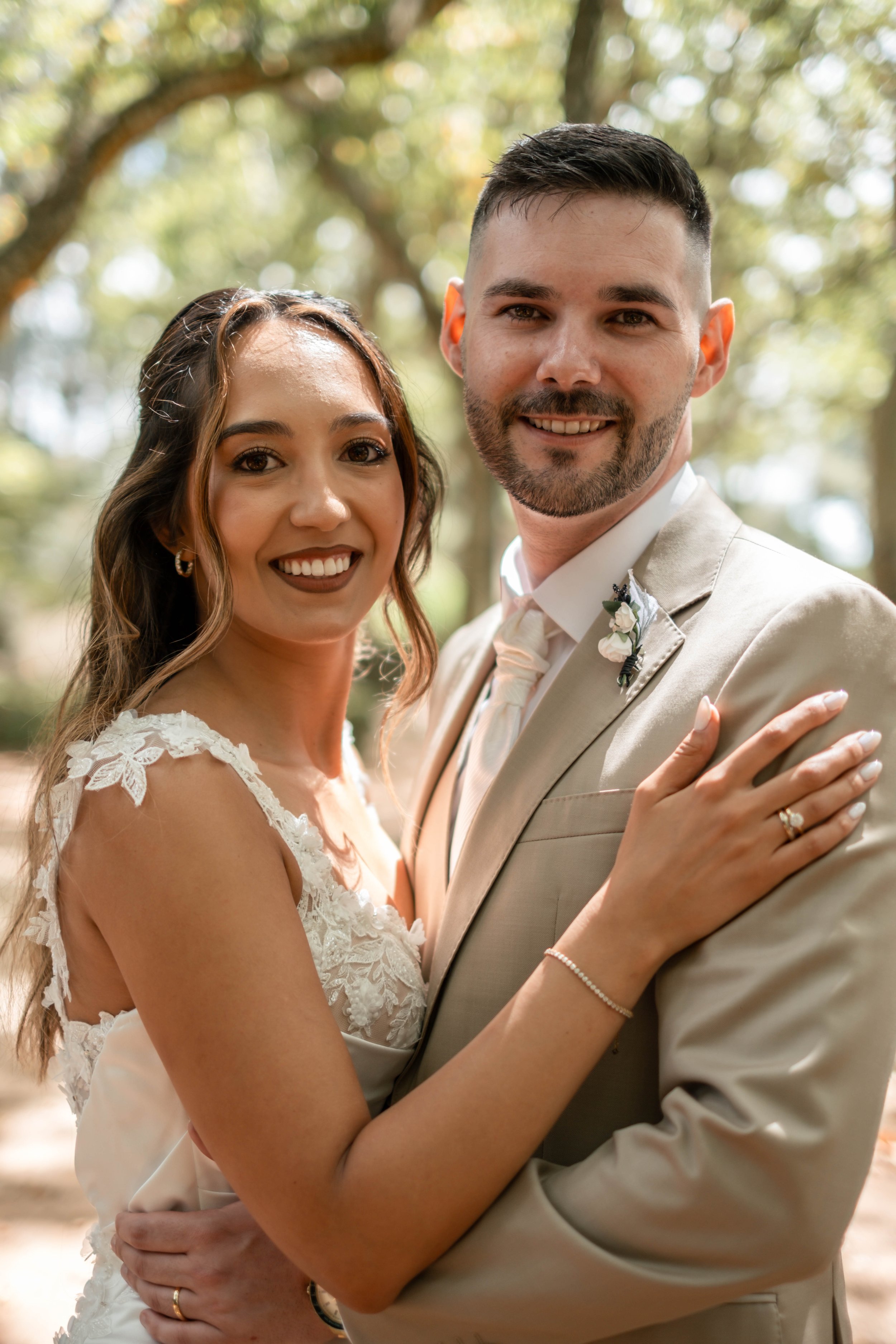 Noivos abraçados a sorrir para a câmara durante sessão de casamento