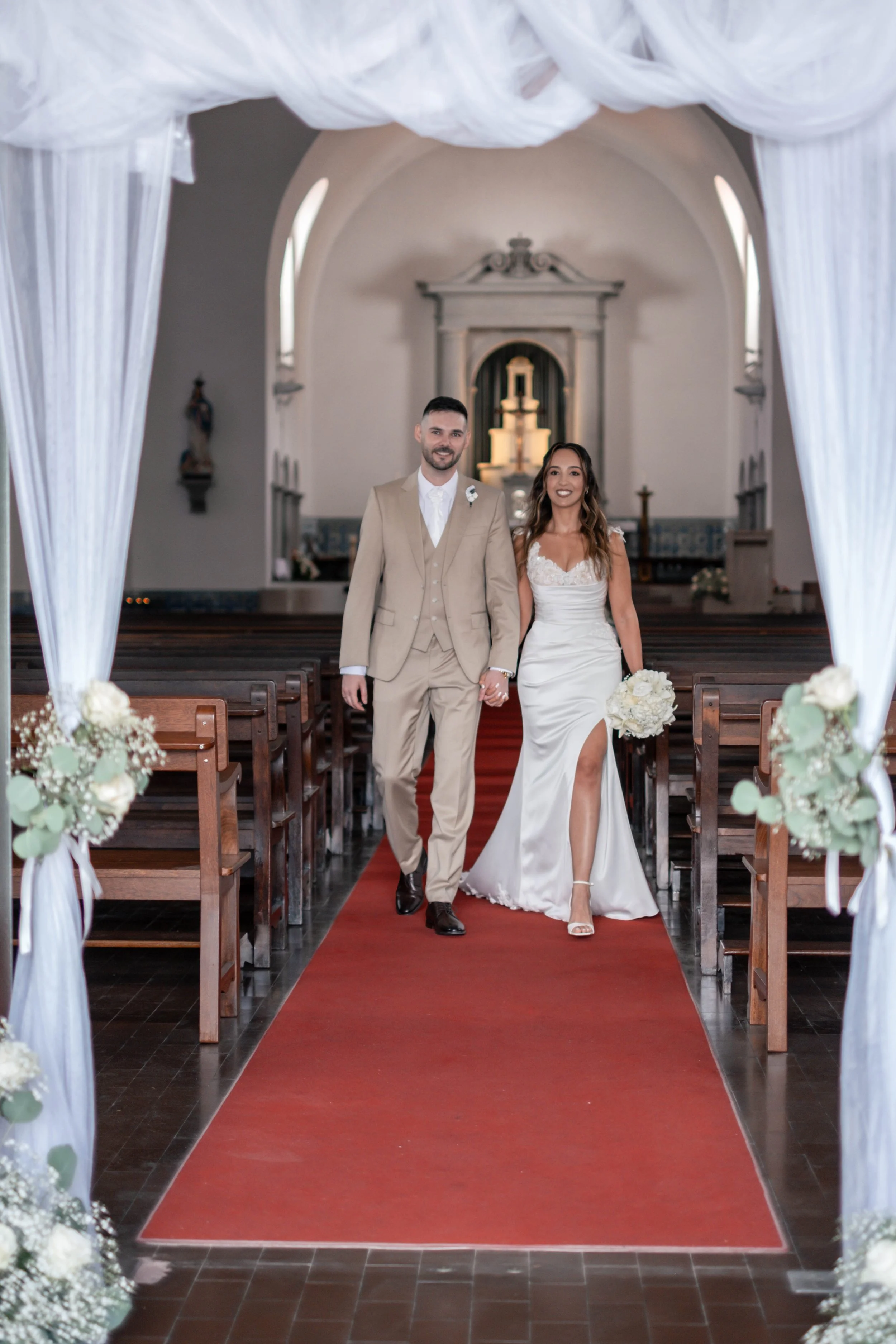 Noivos a caminhar pelo corredor central da igreja depois da cerimónia
