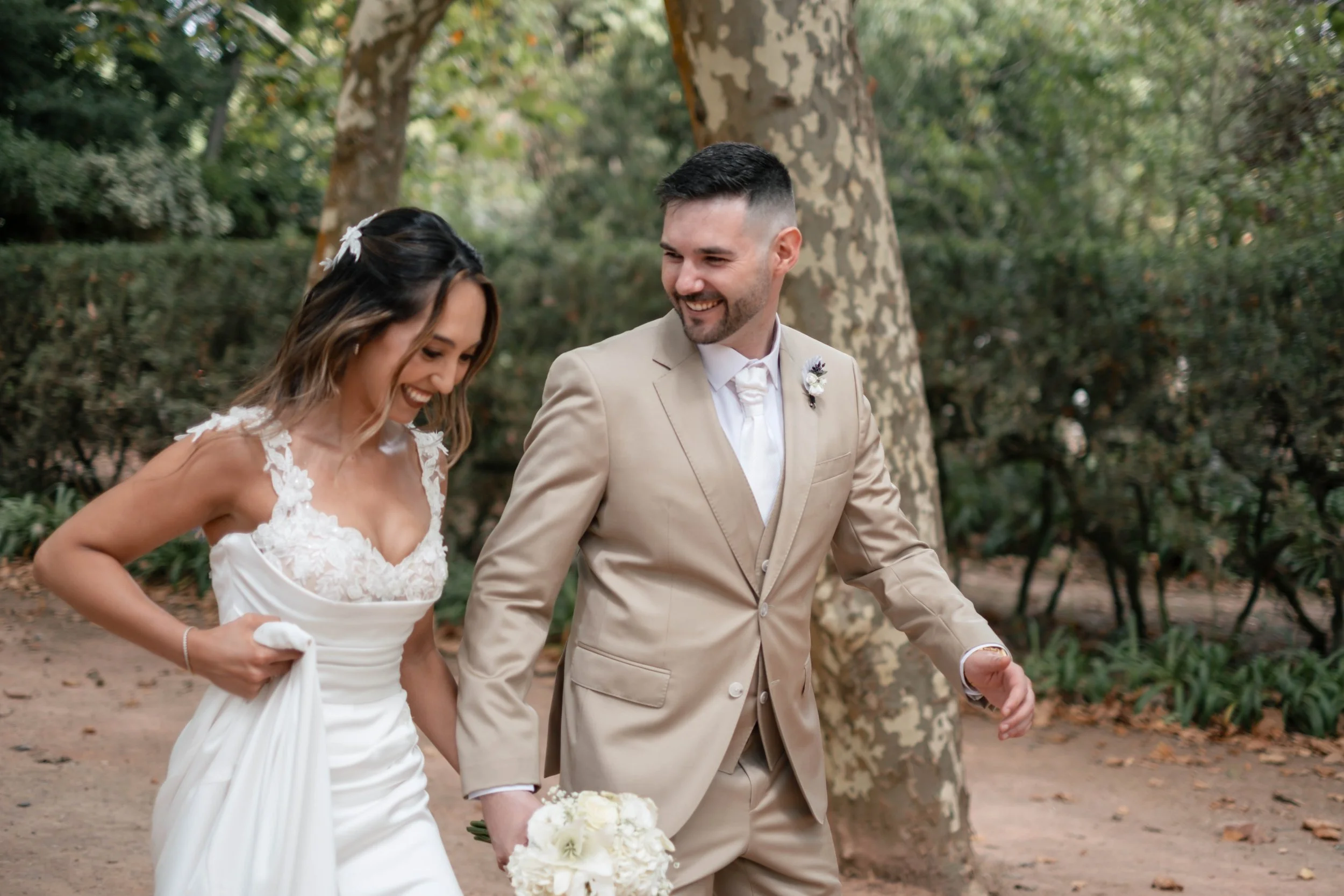 Noivos a caminhar e rir durante sessão de casal no jardim