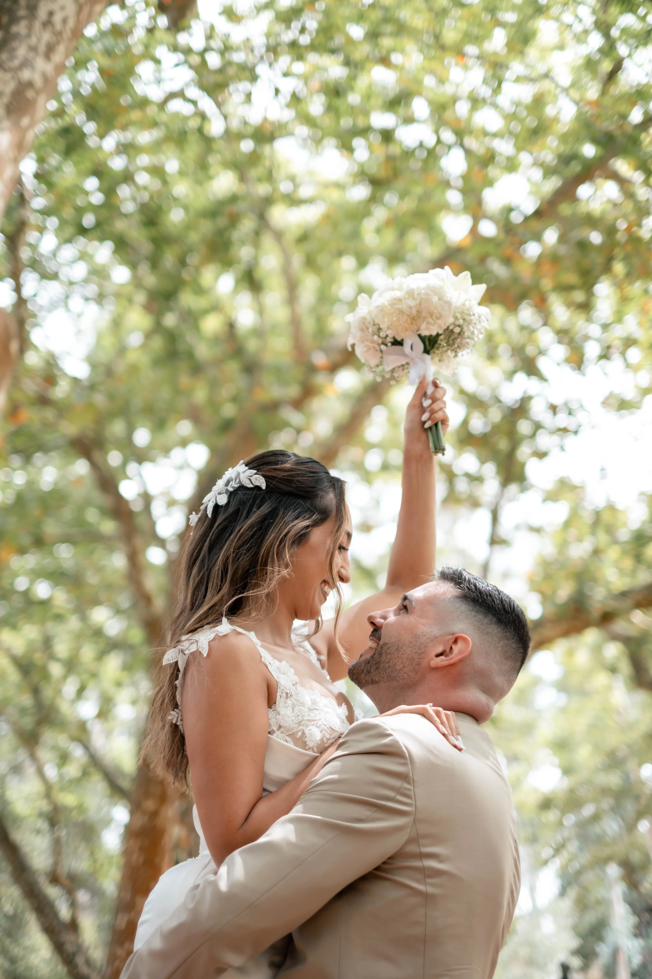 Noiva a segurar o bouquet em pose divertida com o noivo