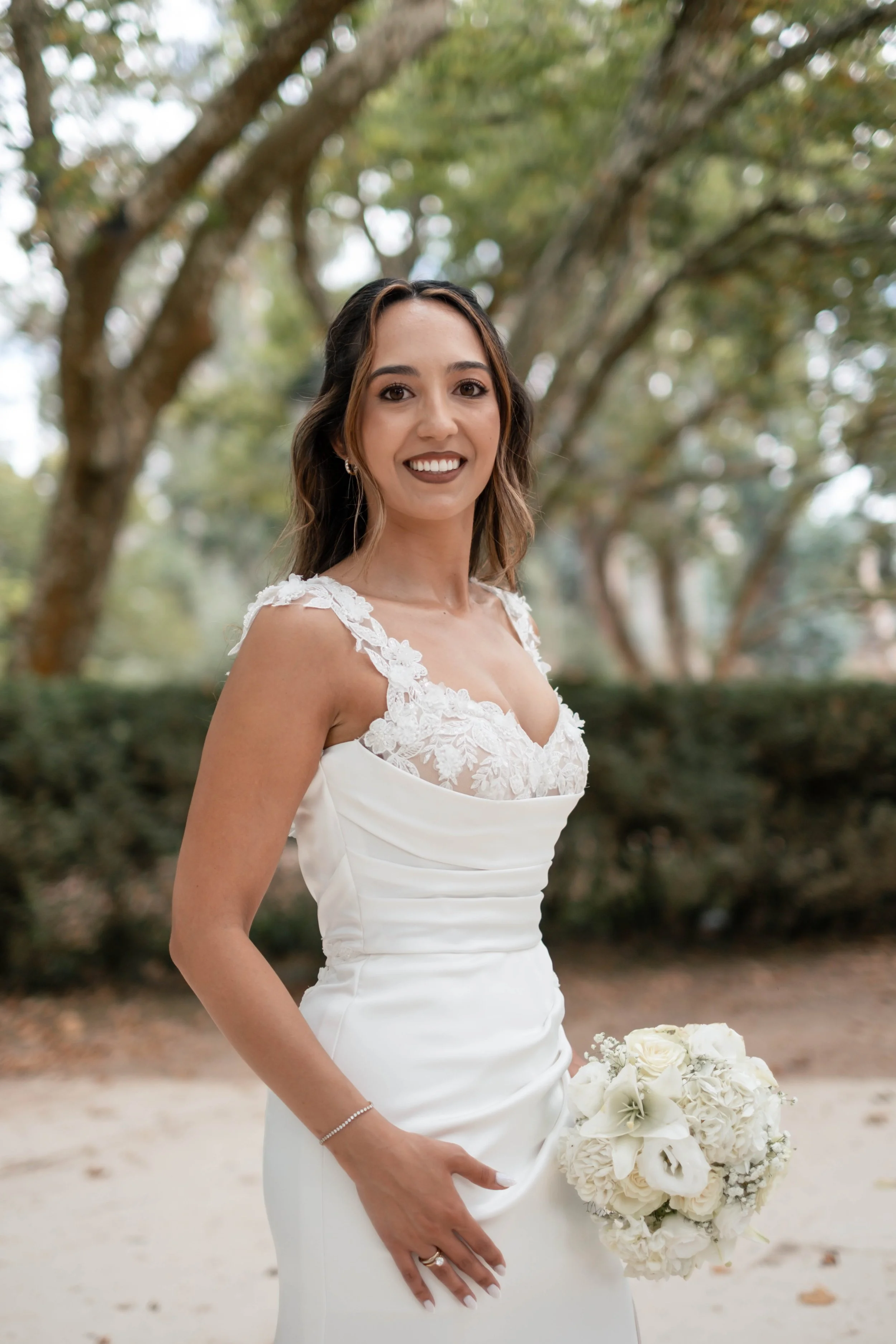 Noiva a sorrir com bouquet branco durante sessão de casamento