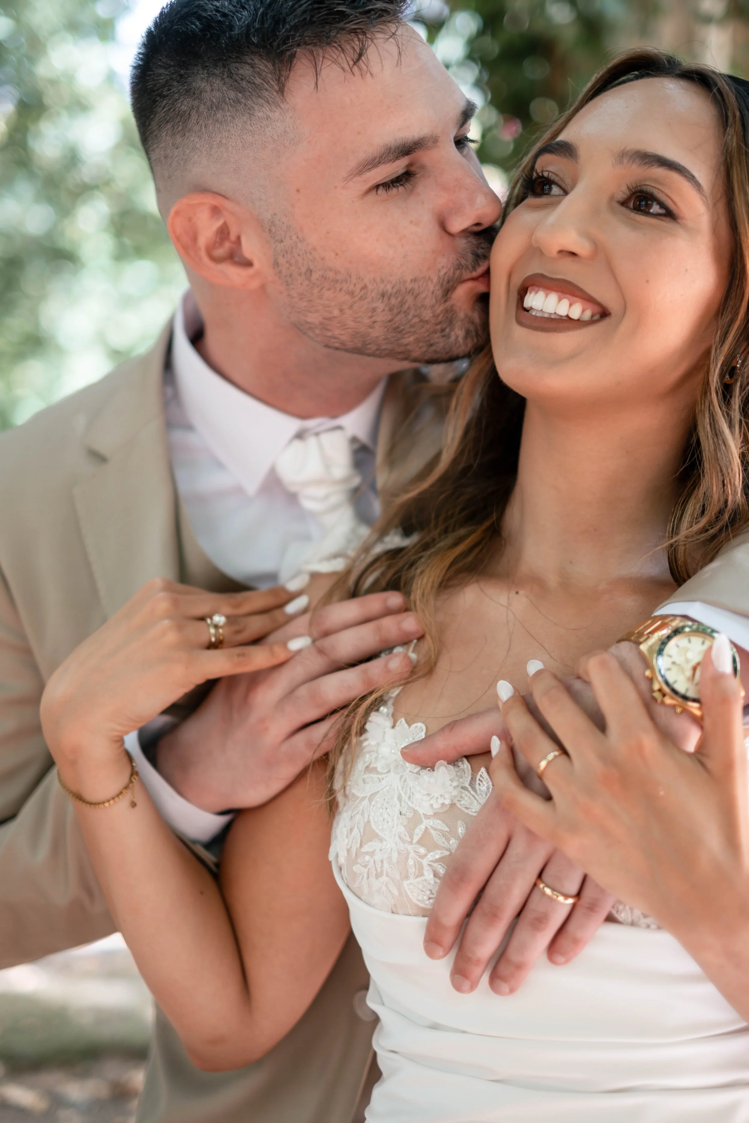 Noivo a beijar a noiva enquanto mostram as alianças
