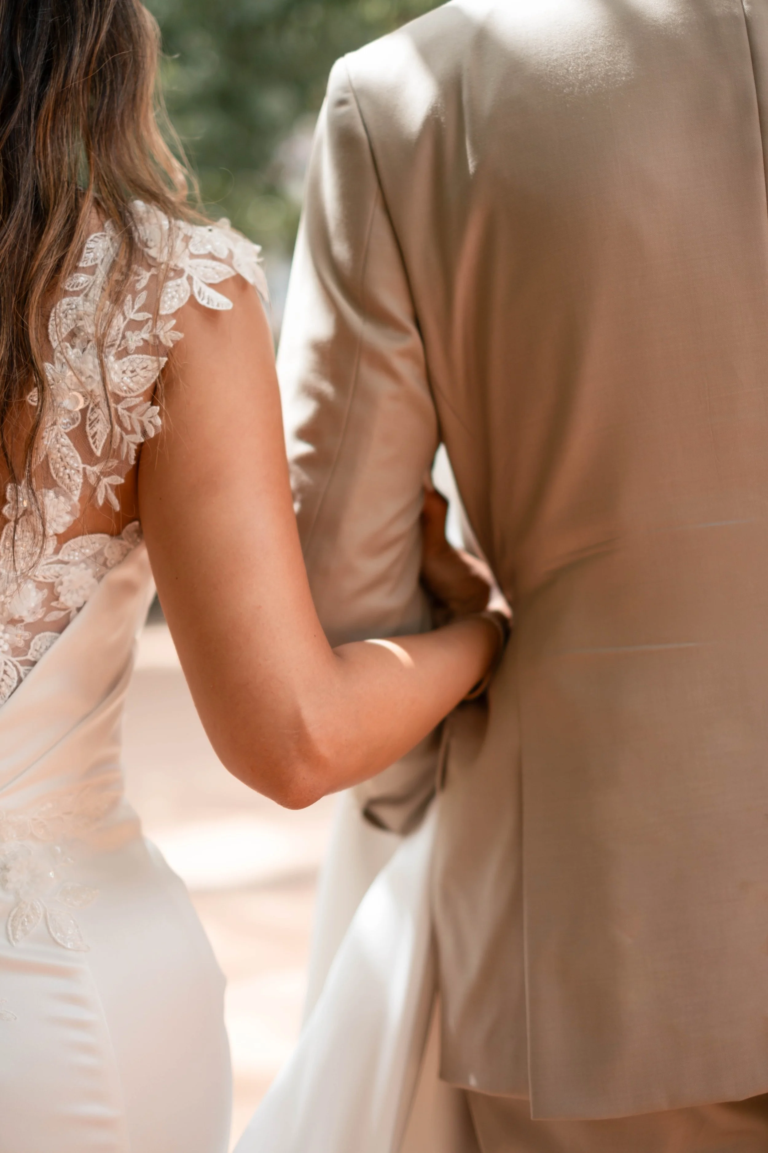Noivos vistos de costas abraçados durante sessão fotográfica de casamento