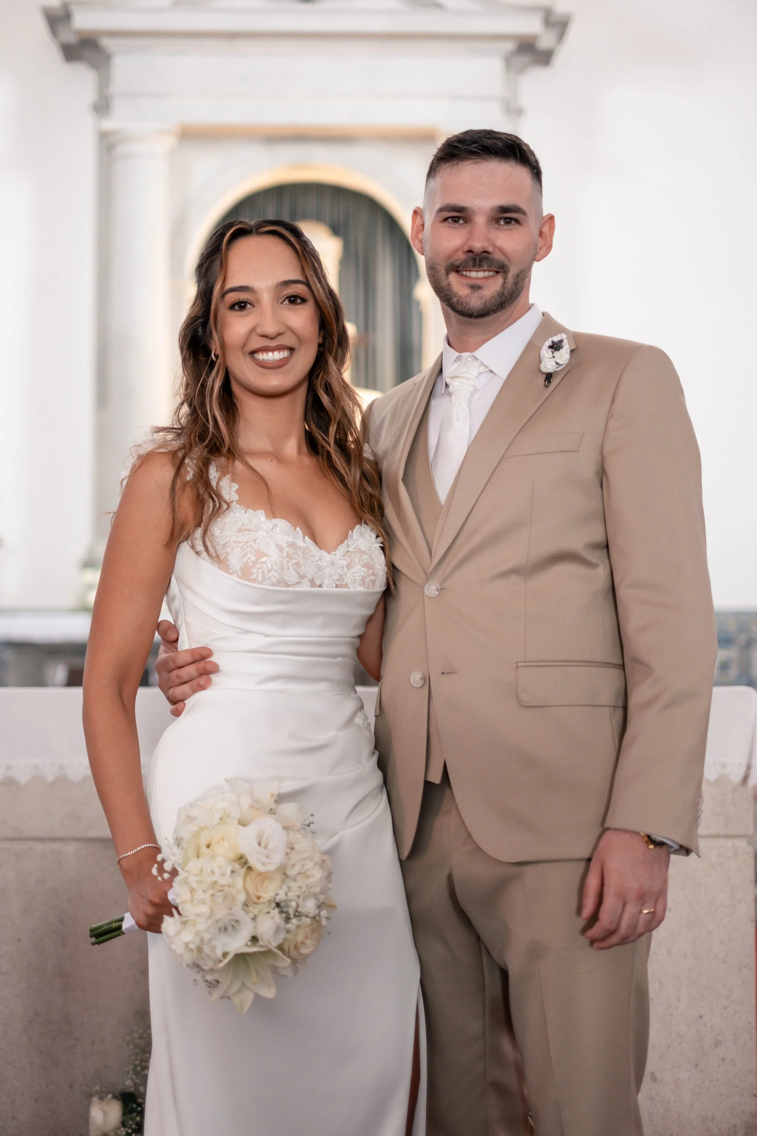 Noivos em retrato formal junto ao altar da igreja