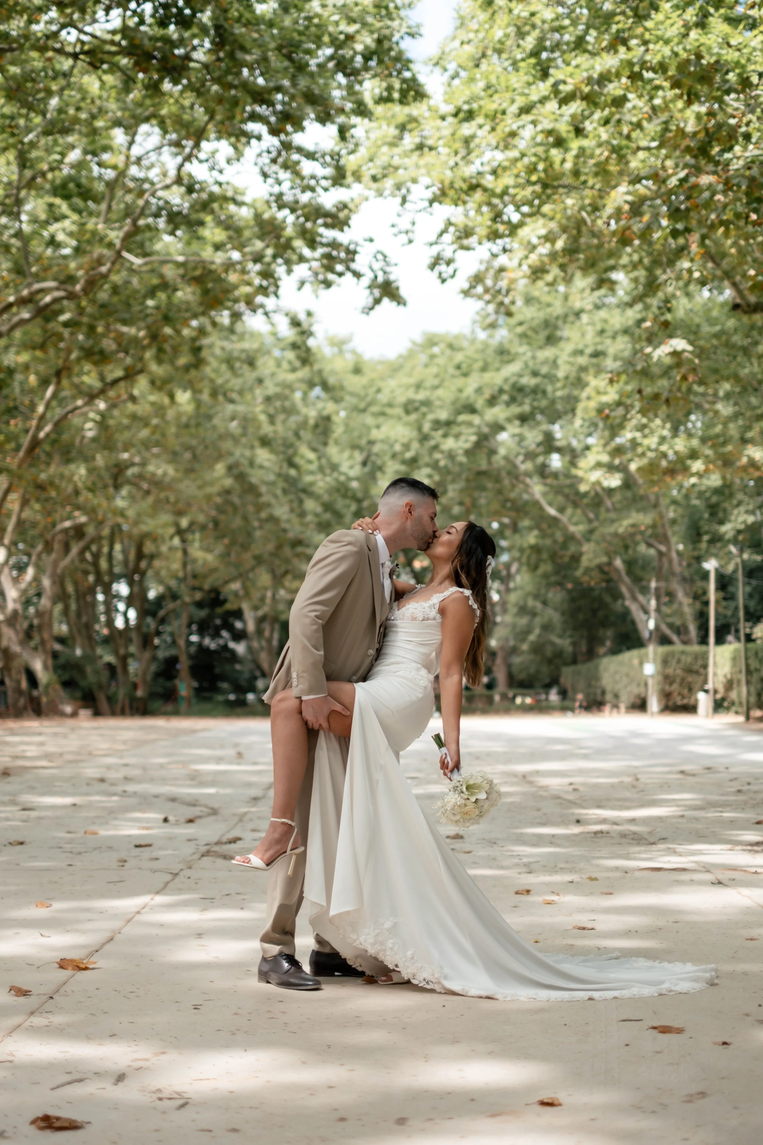 Noivos a beijarem-se num jardim durante sessão de casal