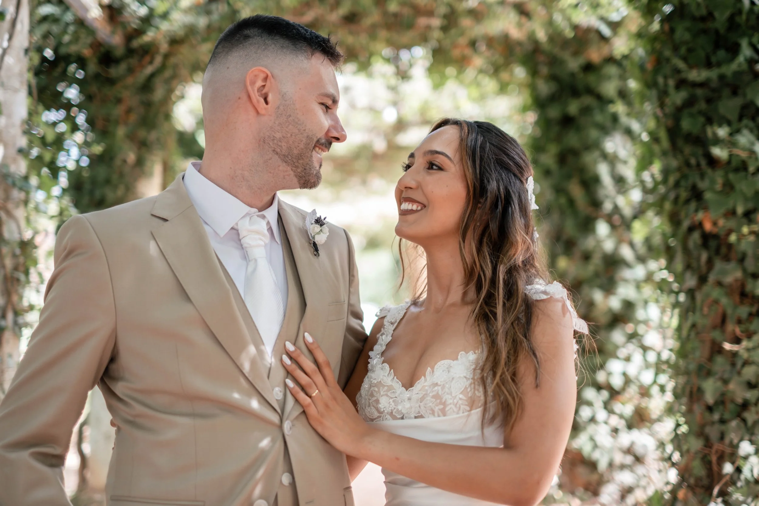 Retrato próximo dos noivos a sorrir durante sessão de casamento