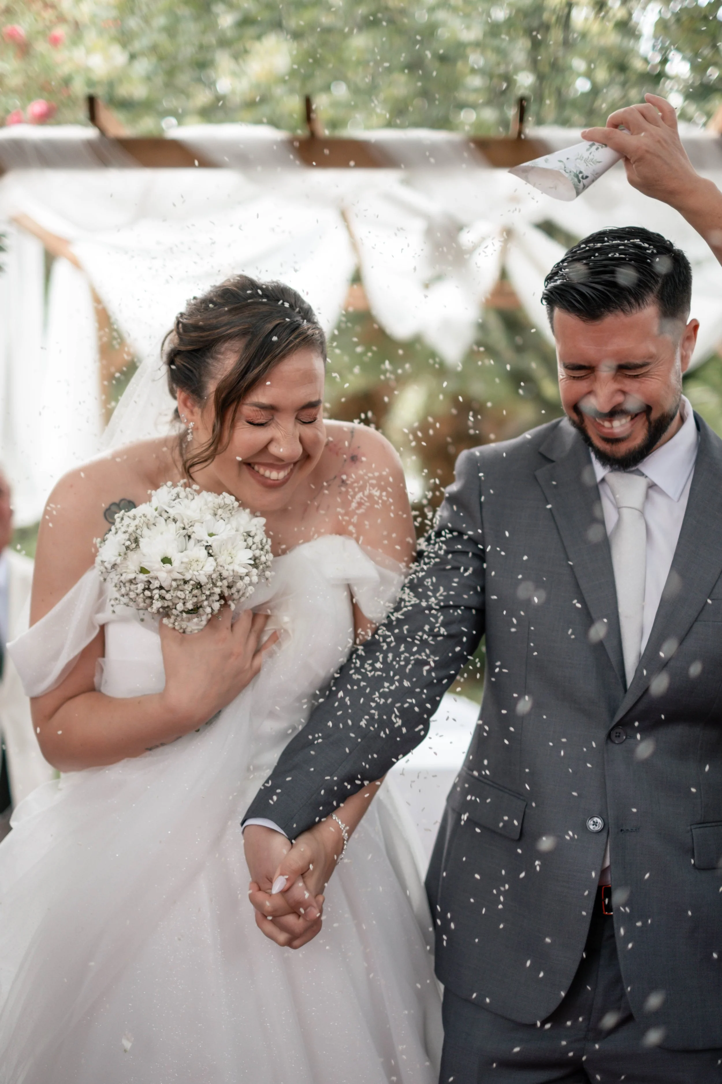 Noivos Cristina e André na saída da cerimónia com uma chuva de arroz