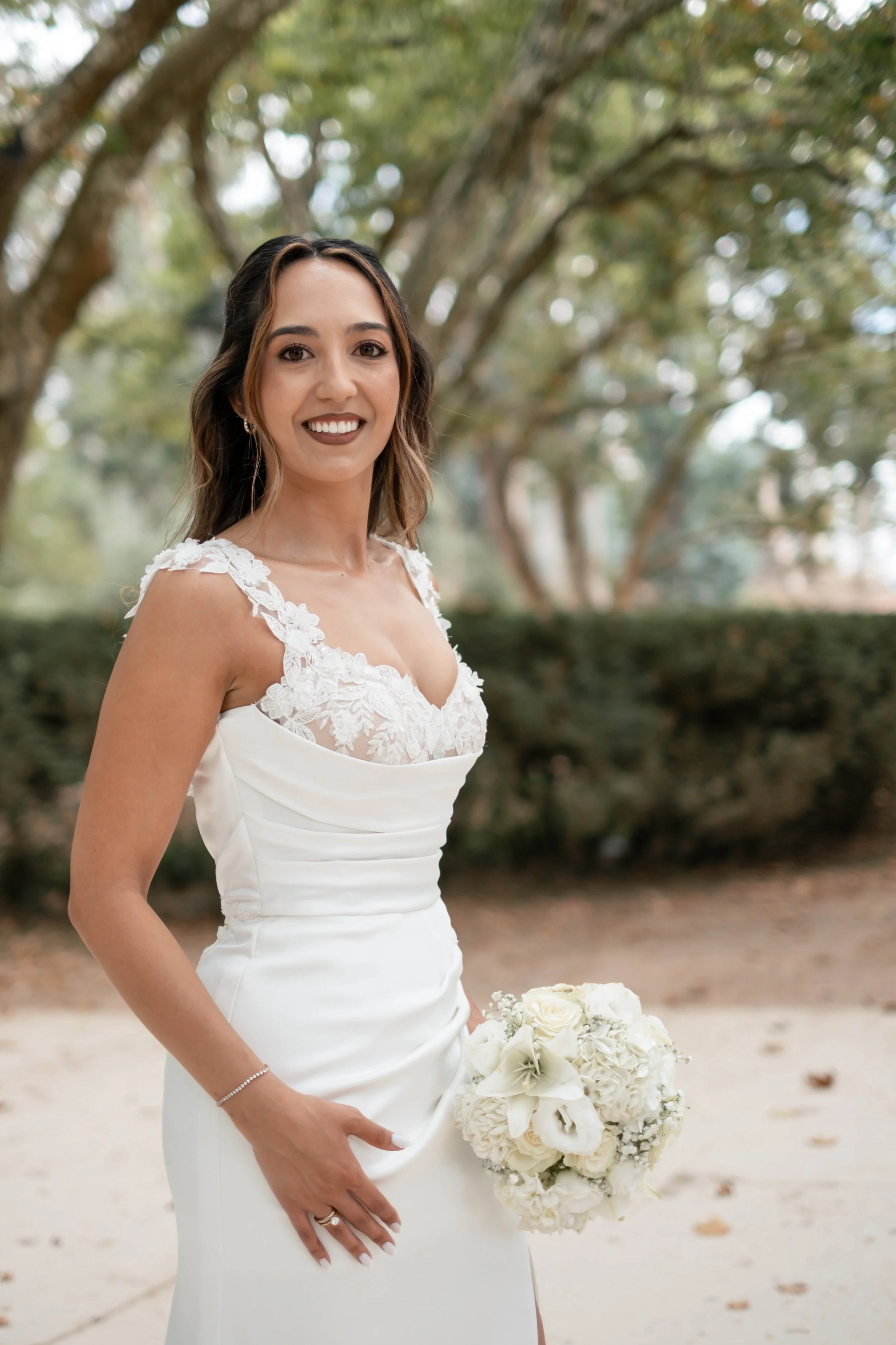 Retrato da noiva com vestido branco e bouquet durante sessão ao ar livre