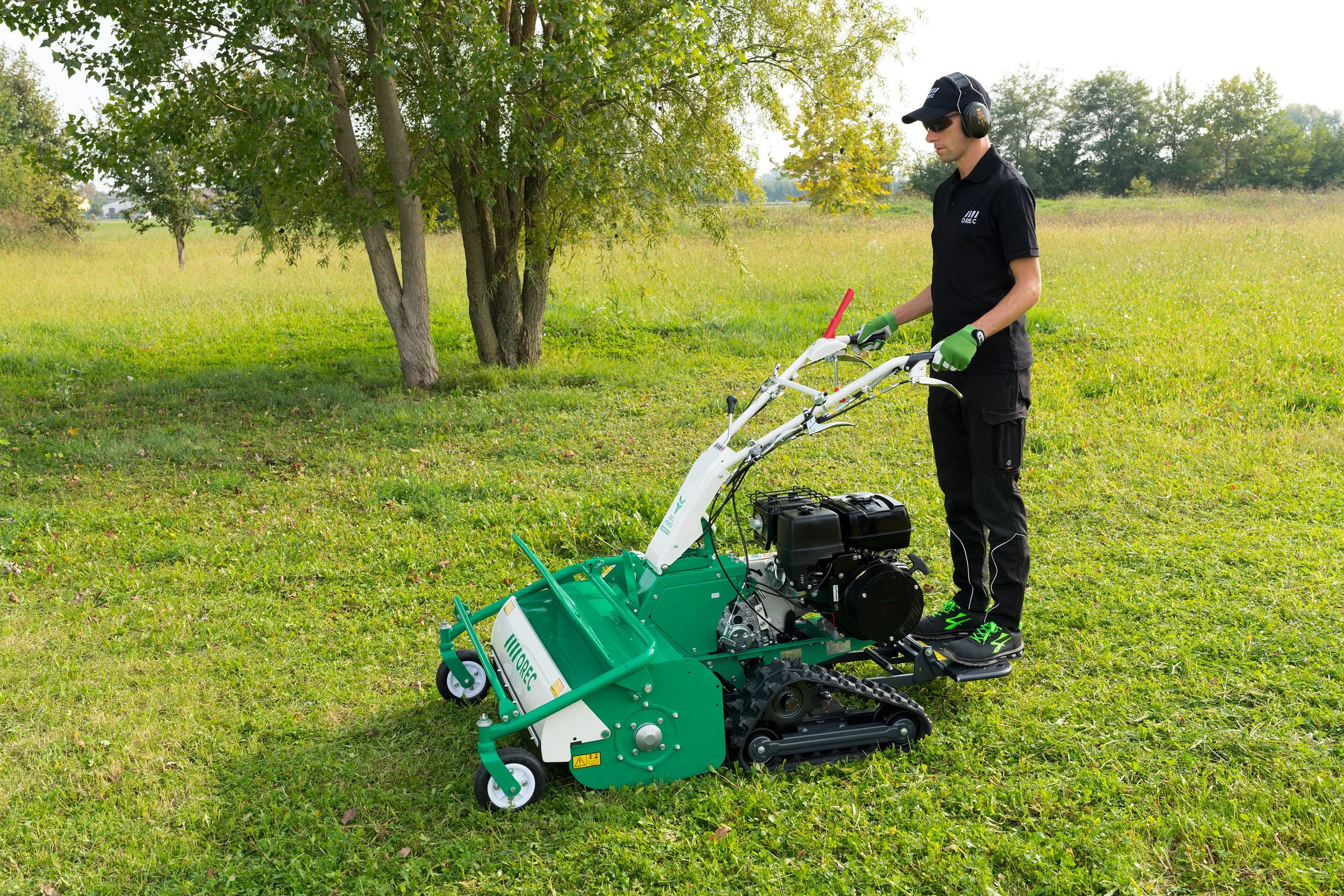 Desbrozadora de eje horizontal con martillos y orugas Orec HRC813 con operario de pie sobre plataforma