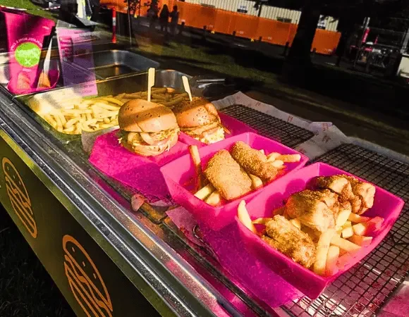 Line of pink betterdish loaded with burger and fries at Moomba Festival 2026
