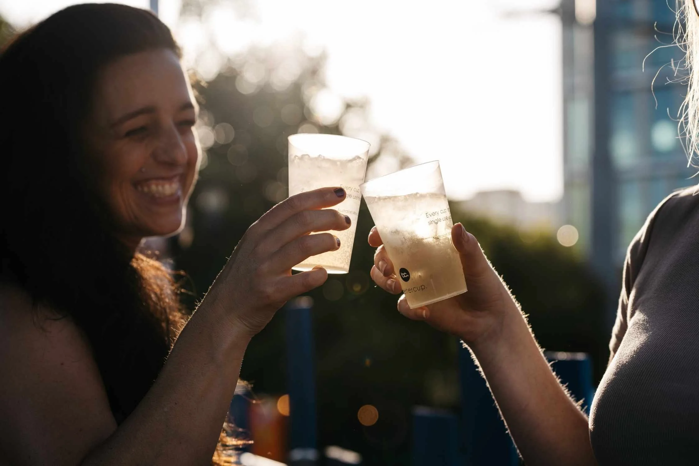 Two people toasting drinks in Bettercup reusable cups at Fringe World 2025.