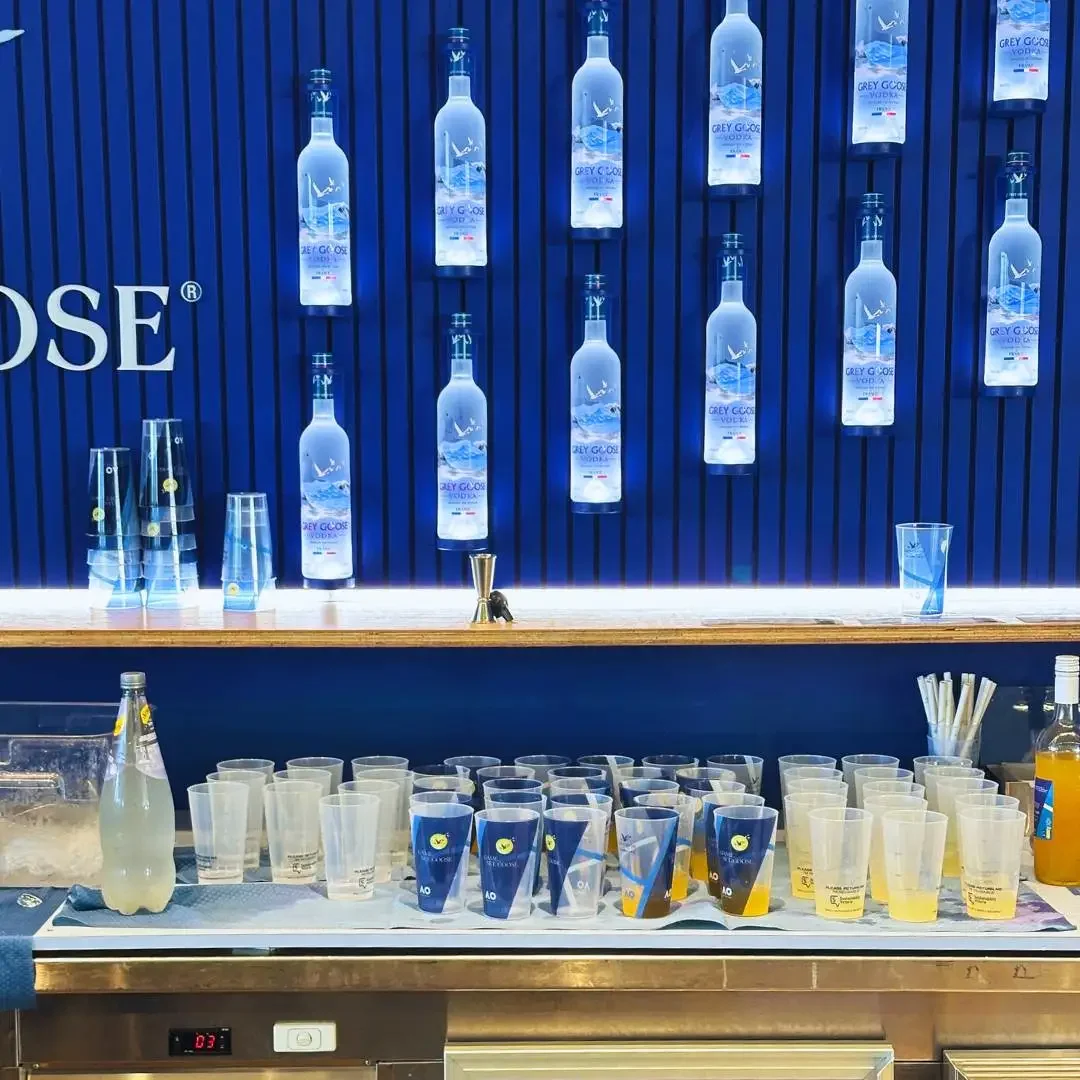 Grey Goose and Sustainability Victoria branded bettercup tumblers and beverage bottles displayed on a bar counter with blue branded backdrop at the Australian Open 2026