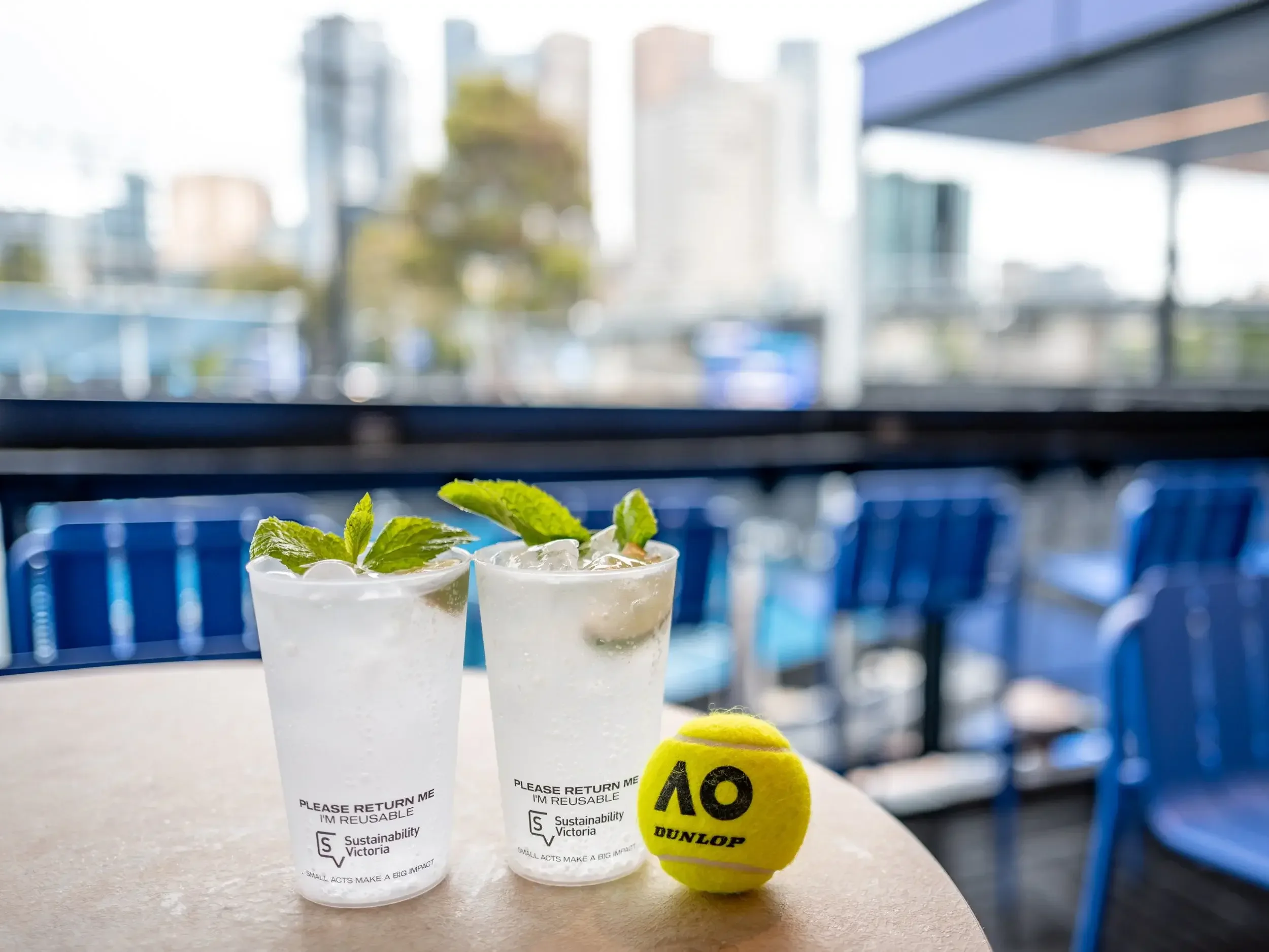 Reusable Bettercup tasters with mint cocktails and Australian Open tennis ball on table.