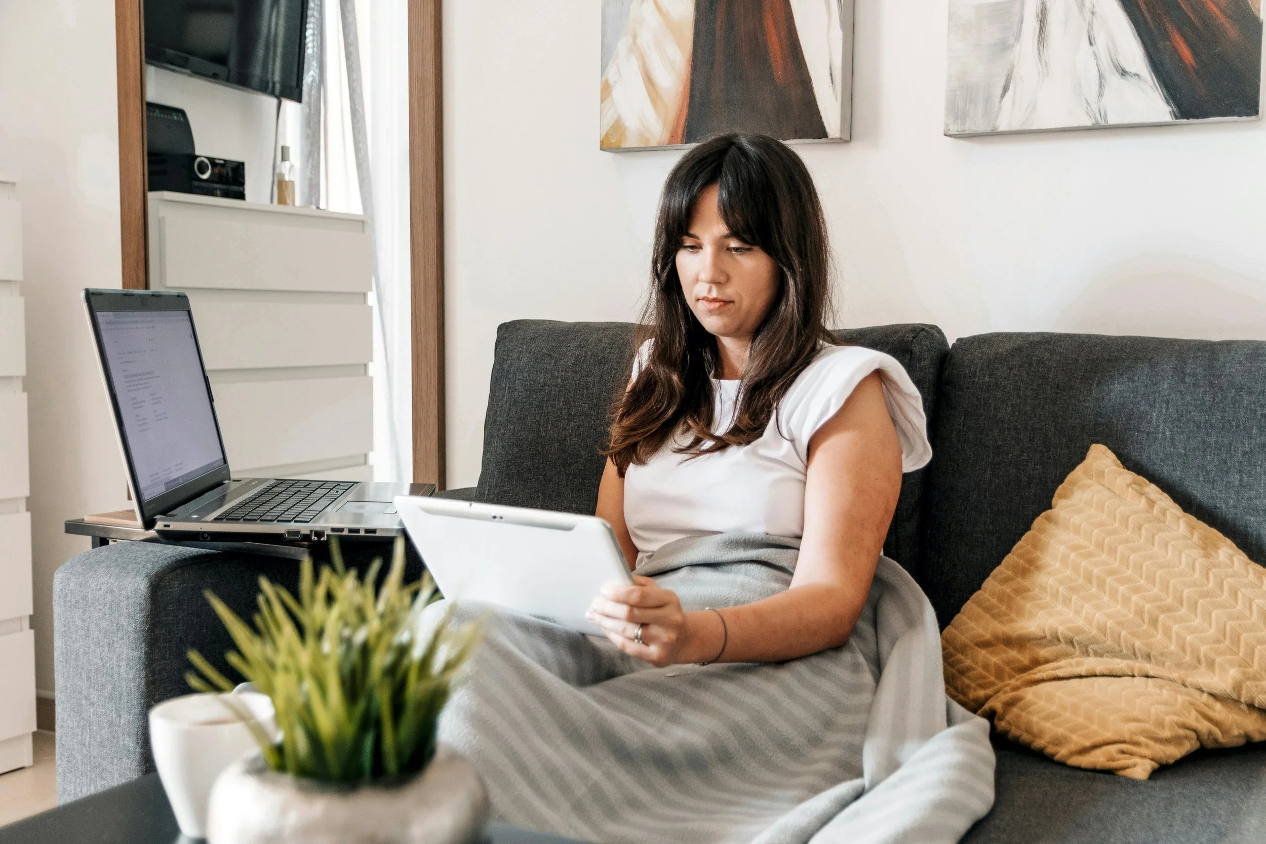 A poised and confident female tech founder working on her laptop from her home office, managing high-functioning anxiety through specialized virtual therapy
