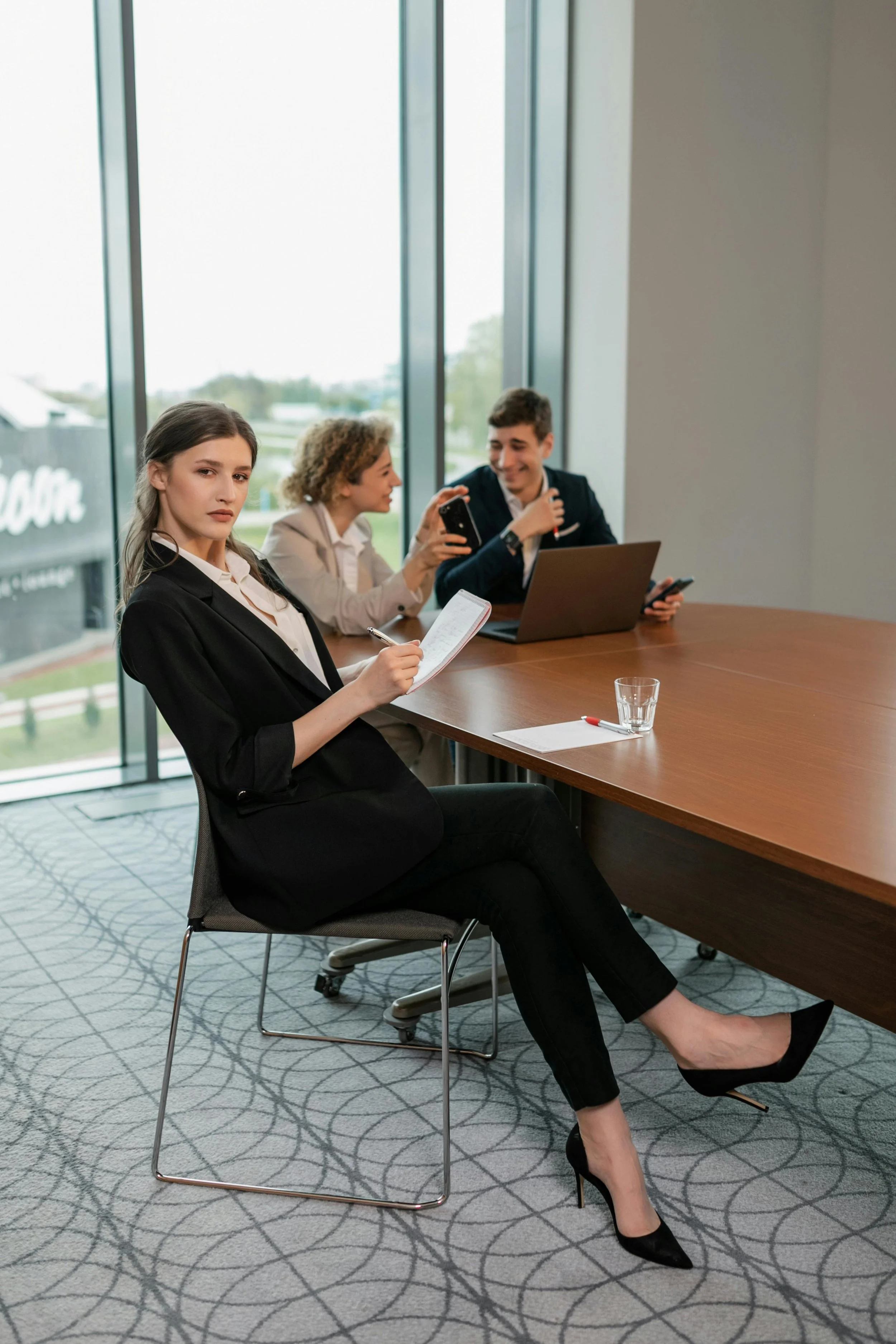 A female corporate leader looking directly at the camera while sitting at an executive boardroom table in downtown San Francisco.