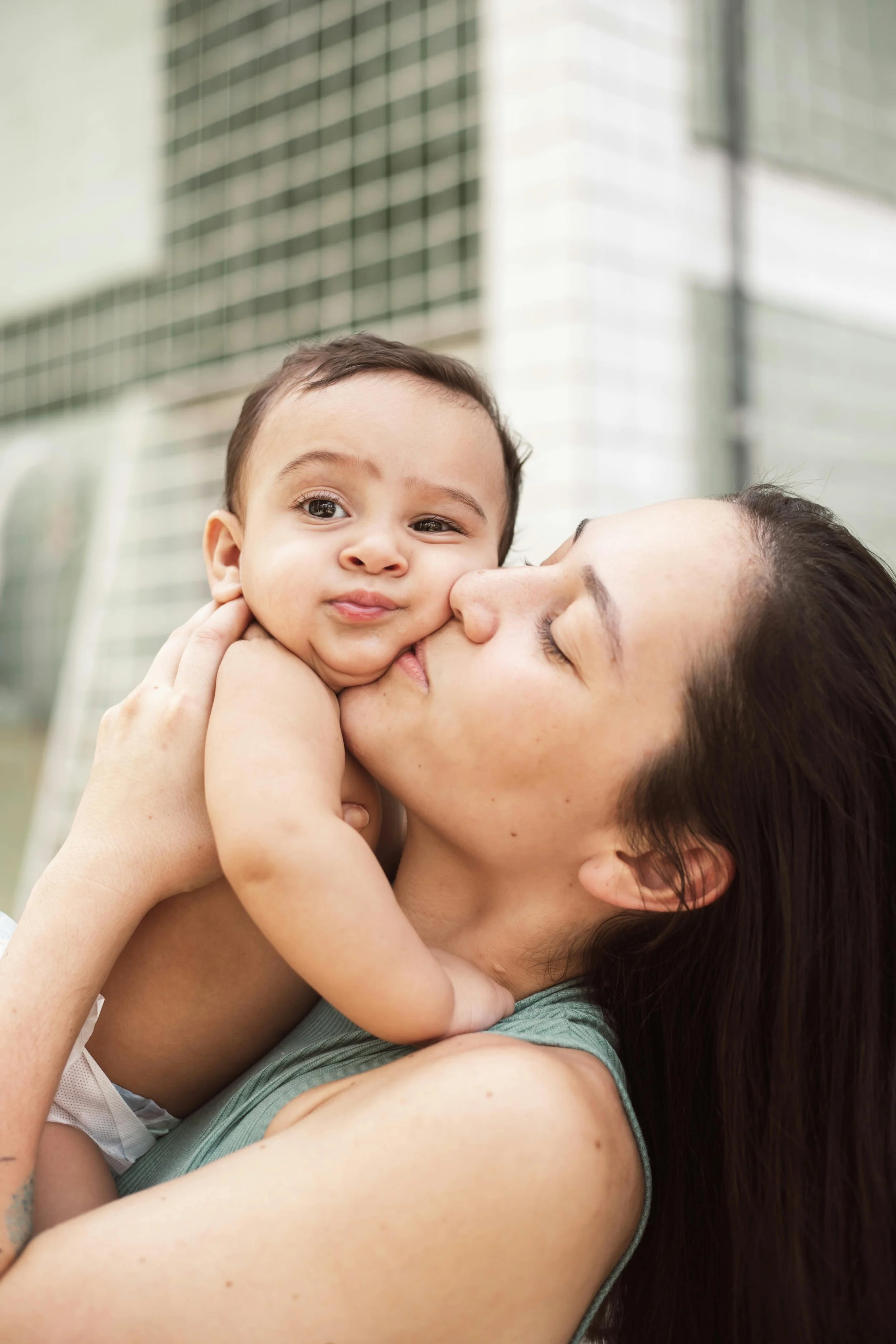 California Mother kissing baby and able to connect after EMDR Therapy with Zyla Care