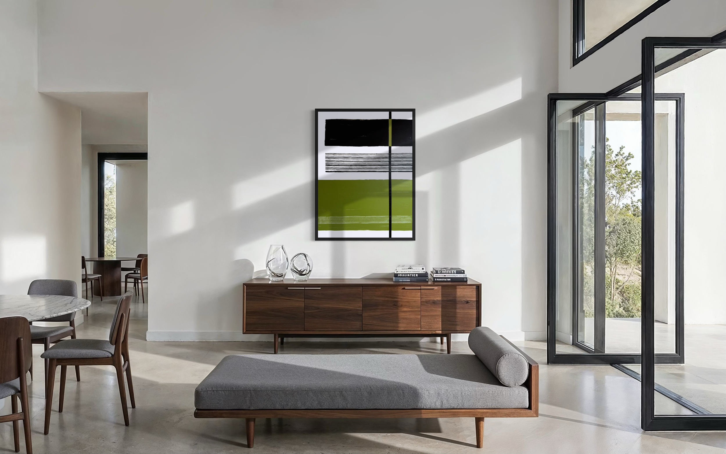 Modern living room with a wooden sideboard, geometric wall art, glass vases, and large windows showing outdoor trees.