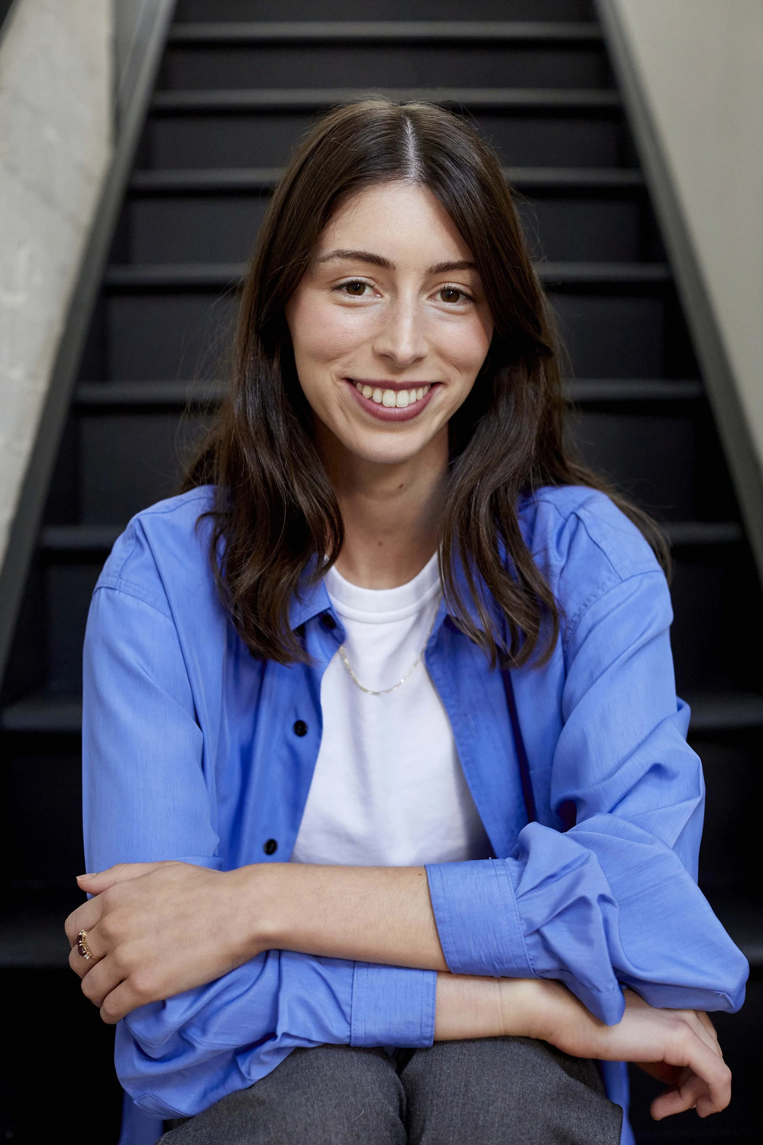 Corporate headshot Melbourne woman sitting on stairs smiling