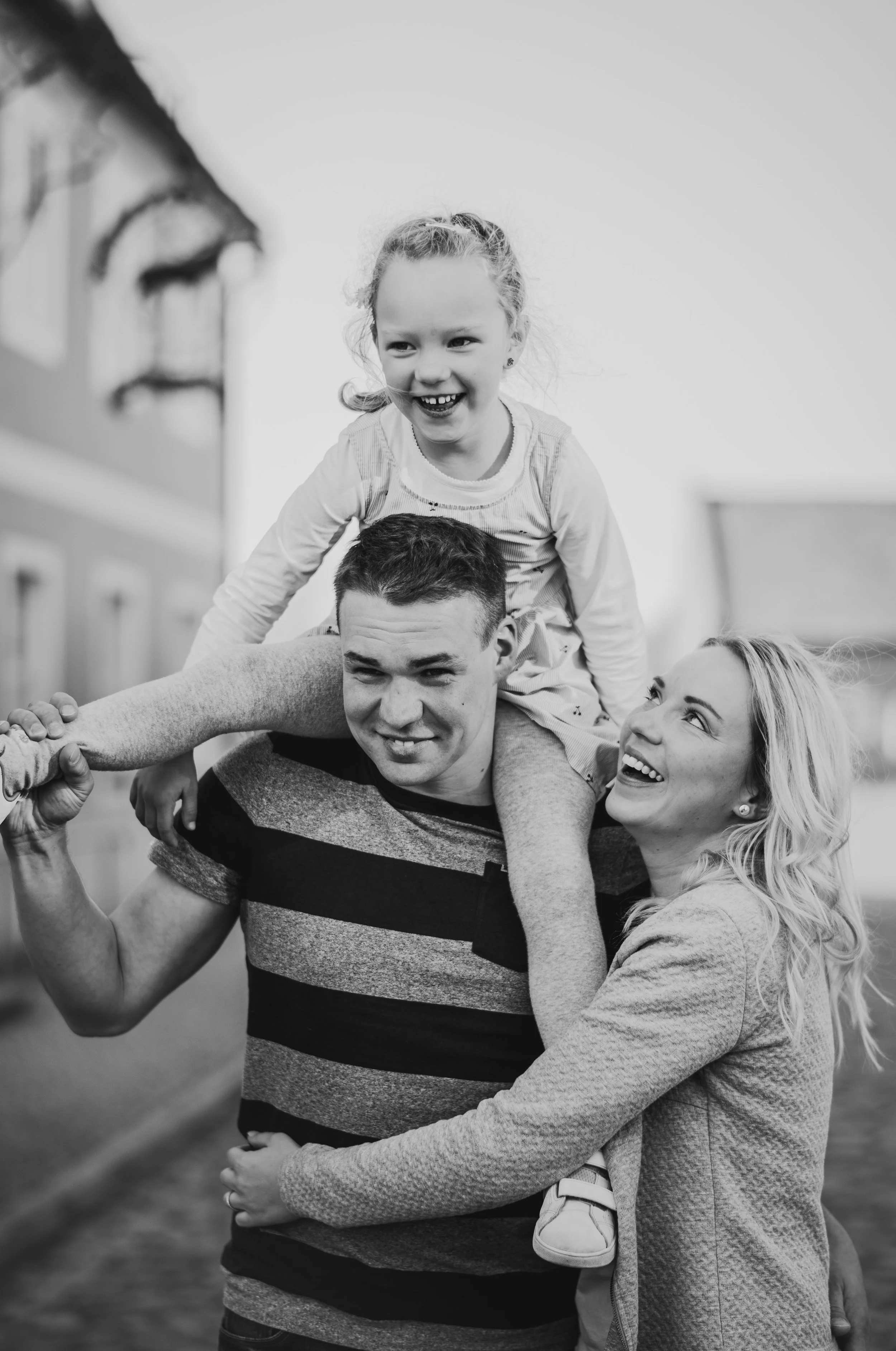 Lebendiger Familienmoment in Schwarzweiß: viel Lachen, Bewegung und Nähe – ein echtes Action-Foto, wie es beim Familien shooting ganz nebenbei entsteht.
