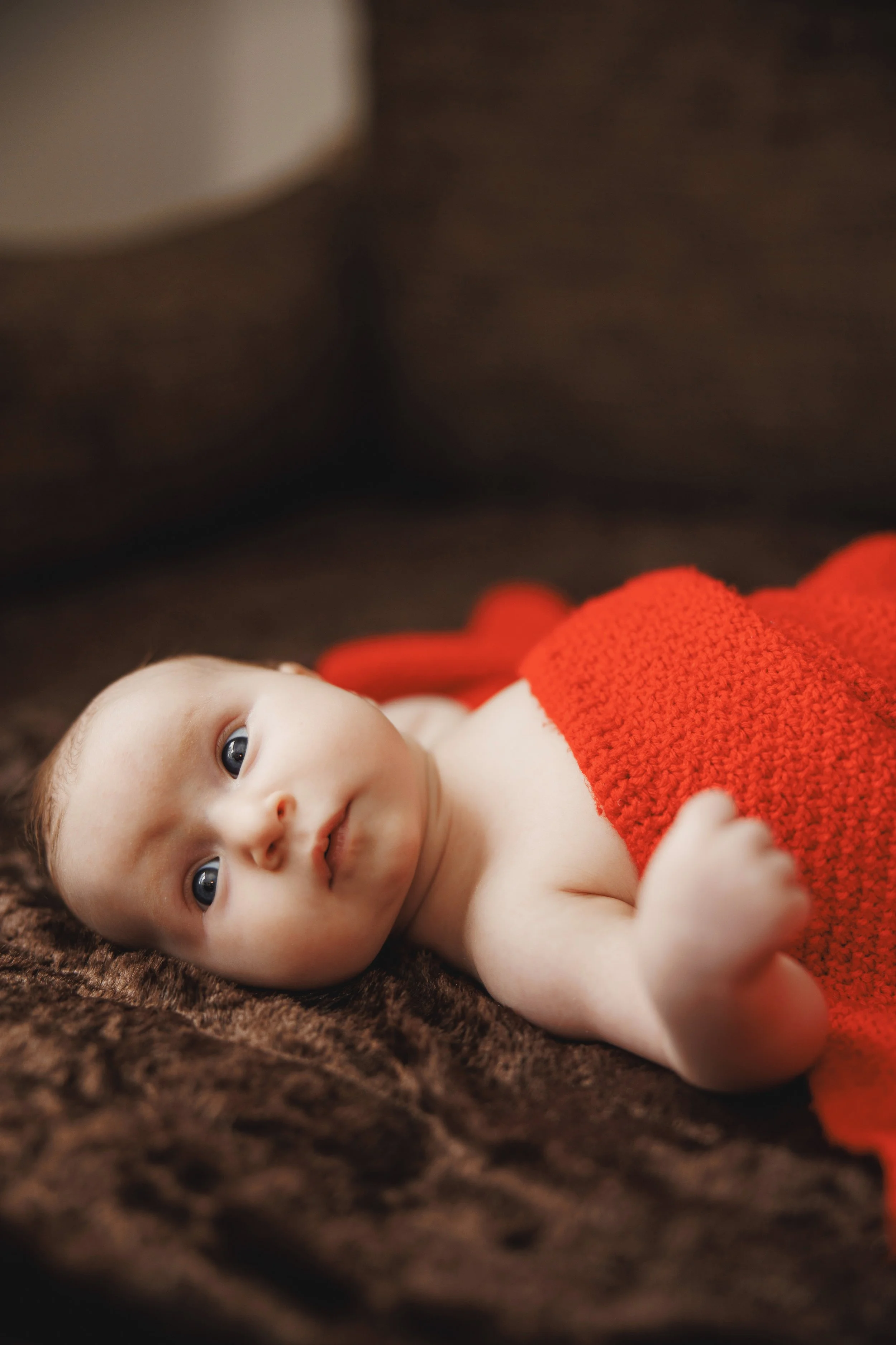 Neugeborenes Baby liegt in warmem Licht auf einer Decke – natürliche Babyfotografie / Homestory in Brandenburg & Sachsen.